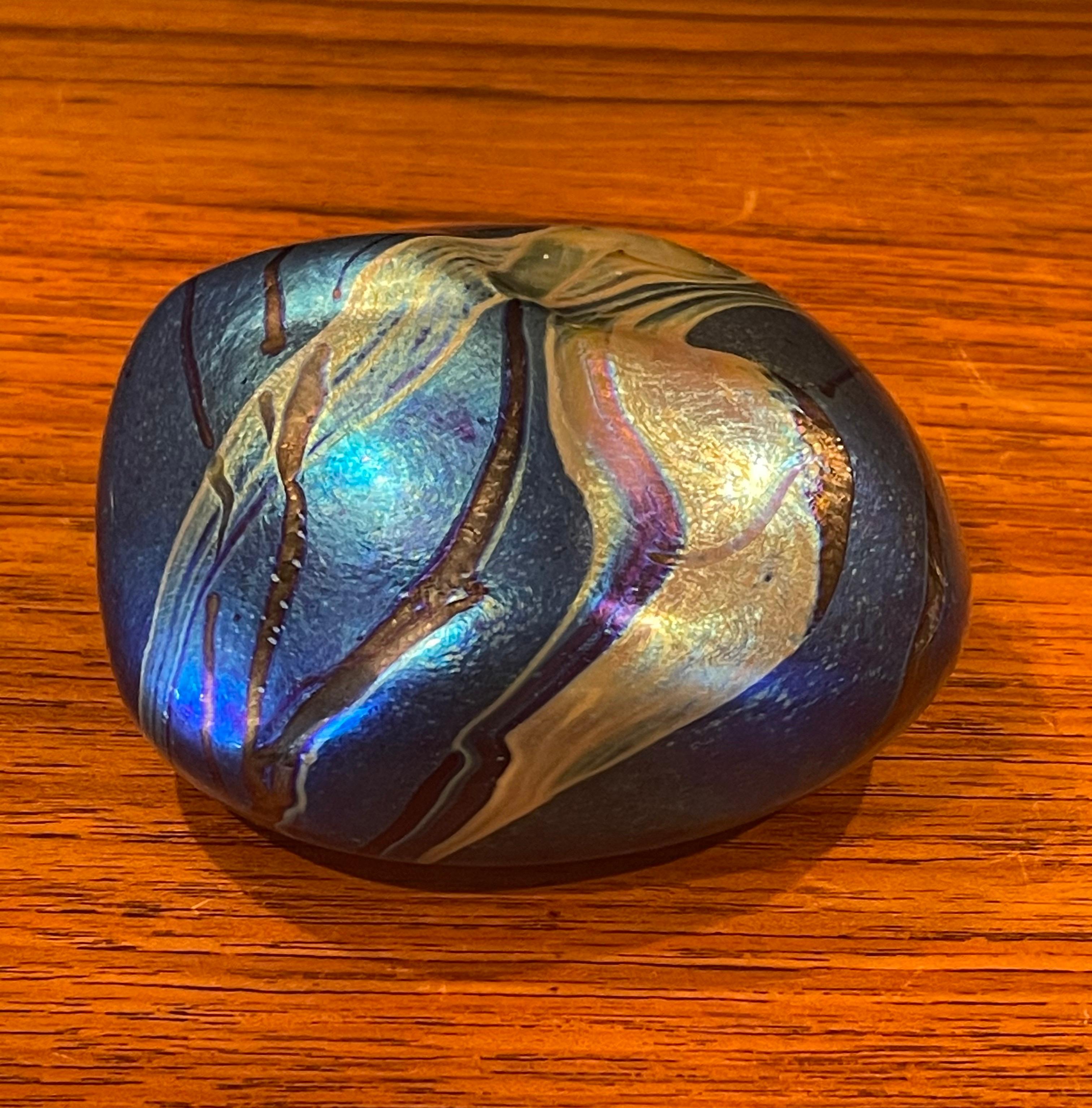 Gorgeous iridescent art glass paperweight by Siddy Langley, circa 2003. The paperweight of compressed circular form over a purple iridescent base with gold and black streaks. Signed and dated on the underside. #1502.