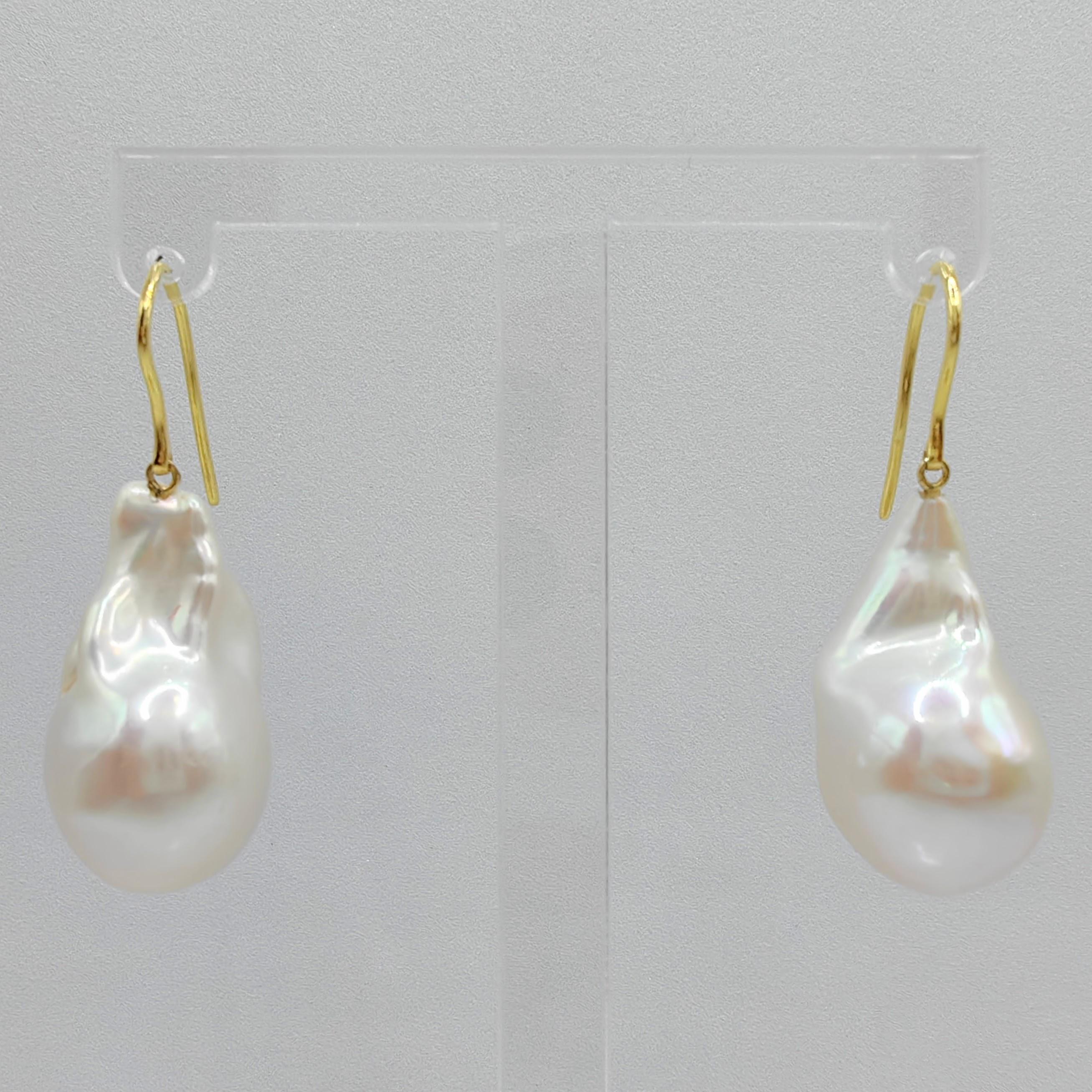 Indulge in the alluring grace of our Iridescent Baroque Pearl Drop Earrings, crafted to captivate and inspire. These remarkable earrings feature stunning Freshwater Cultured Baroque Pearls, boasting a brilliant white hue with a delicate pink
