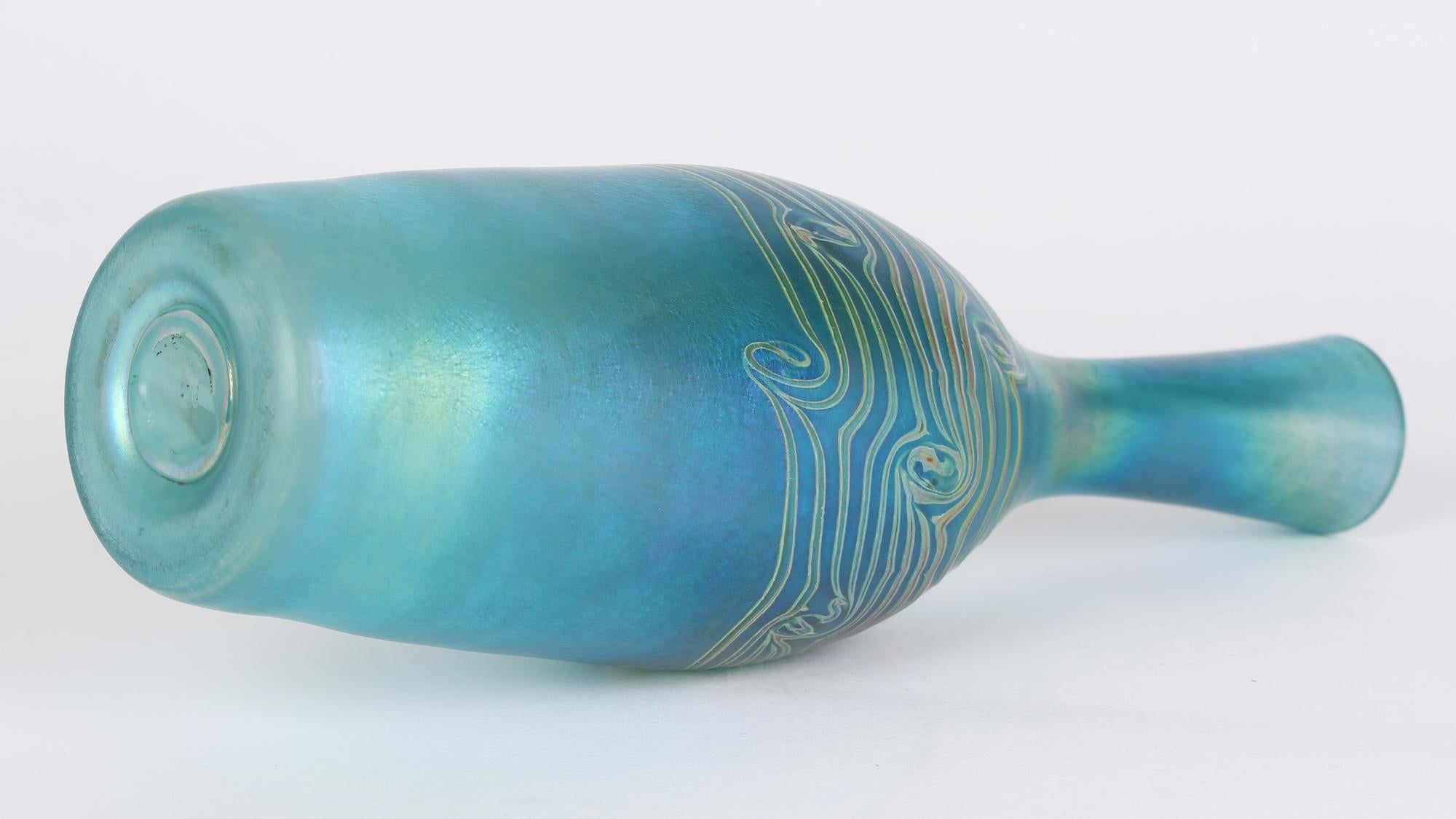 Grand et élégant vase en verre d'art en forme de bouteille bleu irisé avec des motifs de paons traînants datant du 20e siècle. Le vase soufflé à la main est de forme élancée et est magnifiquement réalisé en verre teinté bleu avec une merveilleuse