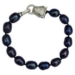 Pulsera de cuentas de vidrio azul iridiscente con cierre de pantera pavé en tono plateado
