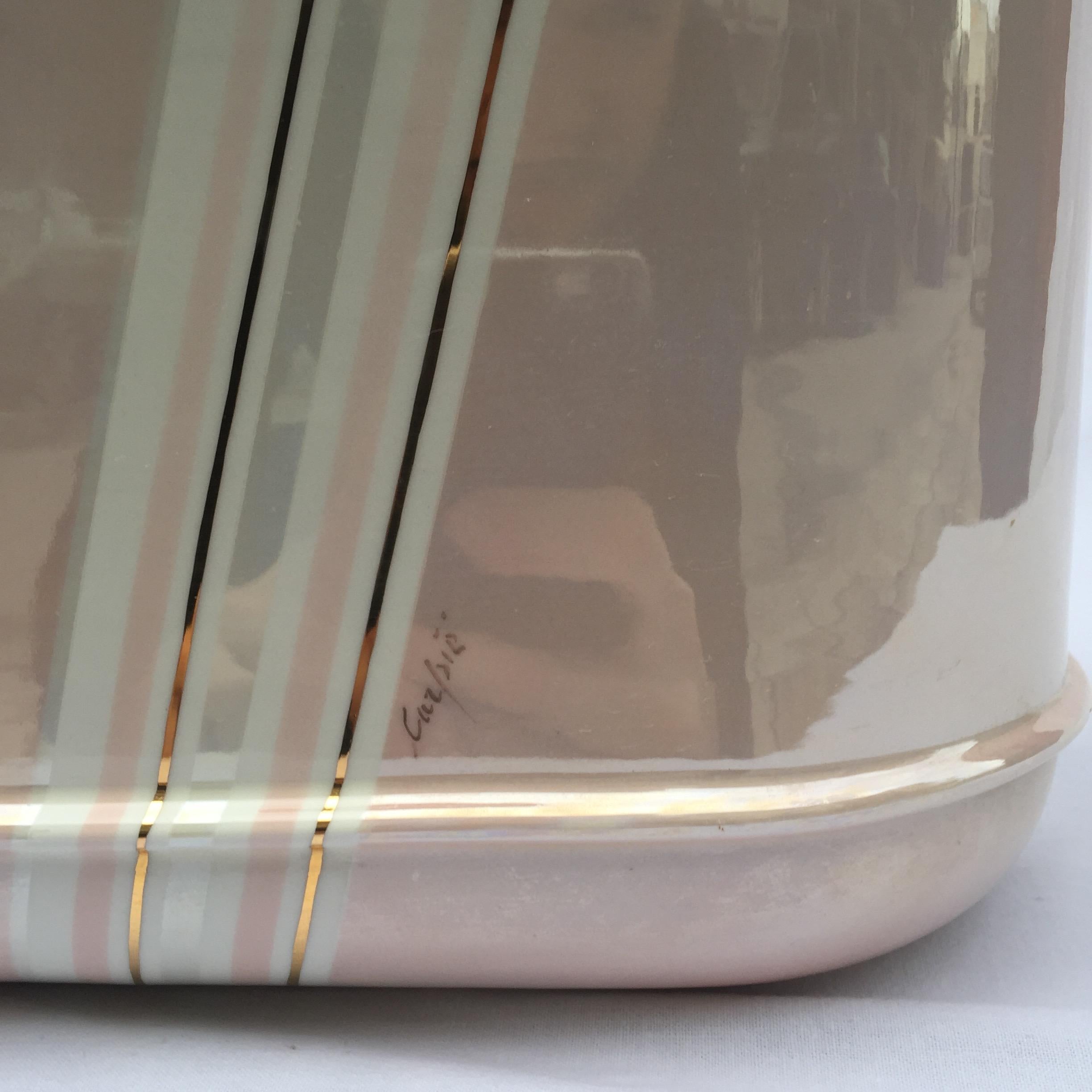 Una gran lámpara de mesa rosa pastel y marfil de los maestros italianos de la porcelana Carpie Nove, con forma ovalada oblonga y decorada con detalles en oro de 24 quilates.

Esta lámpara de sobremesa se originó en Italia en la década de 1980 y