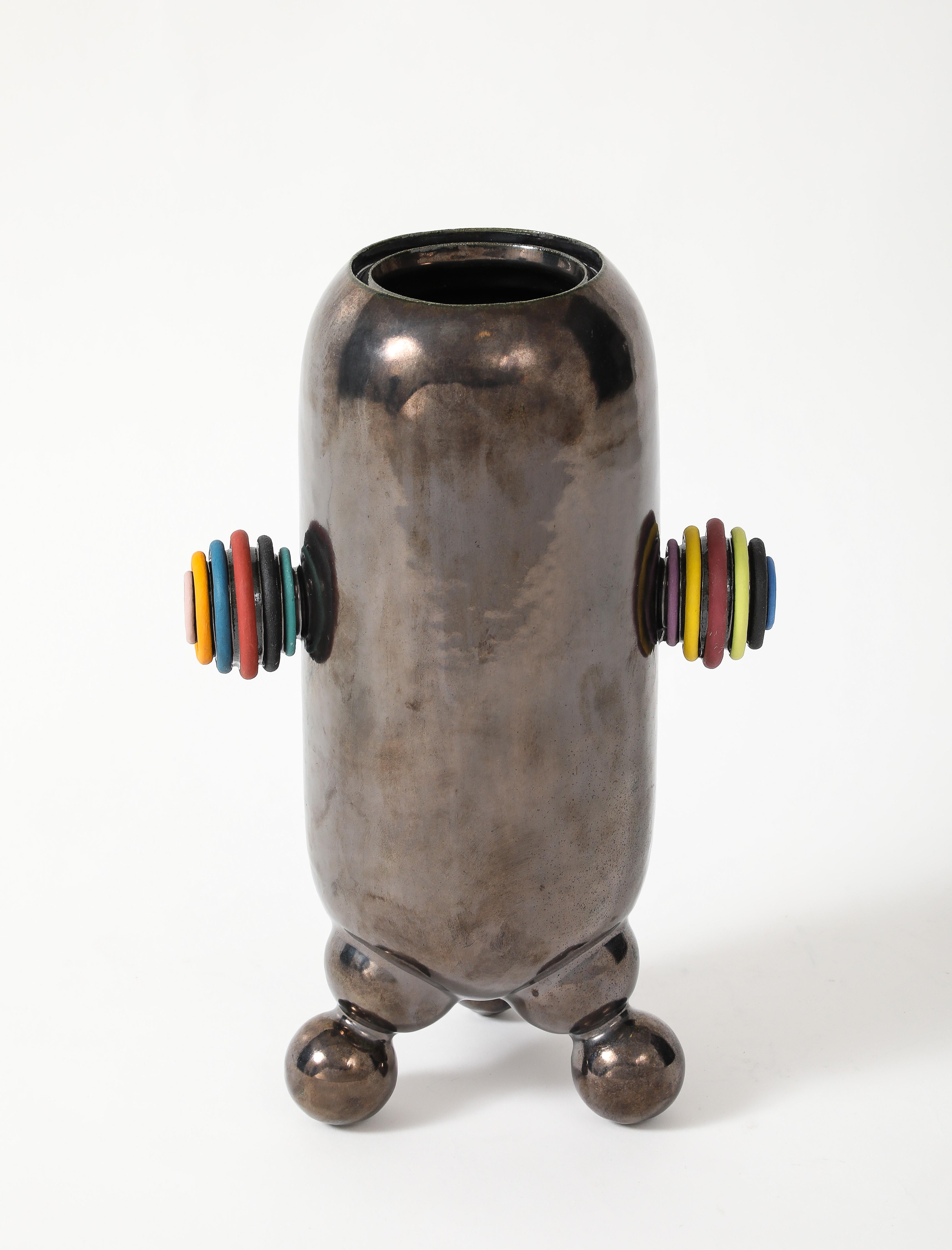 White sculpture clay, finished in metallic silver glaze.  Colored velvet underglaze on handles

Signed