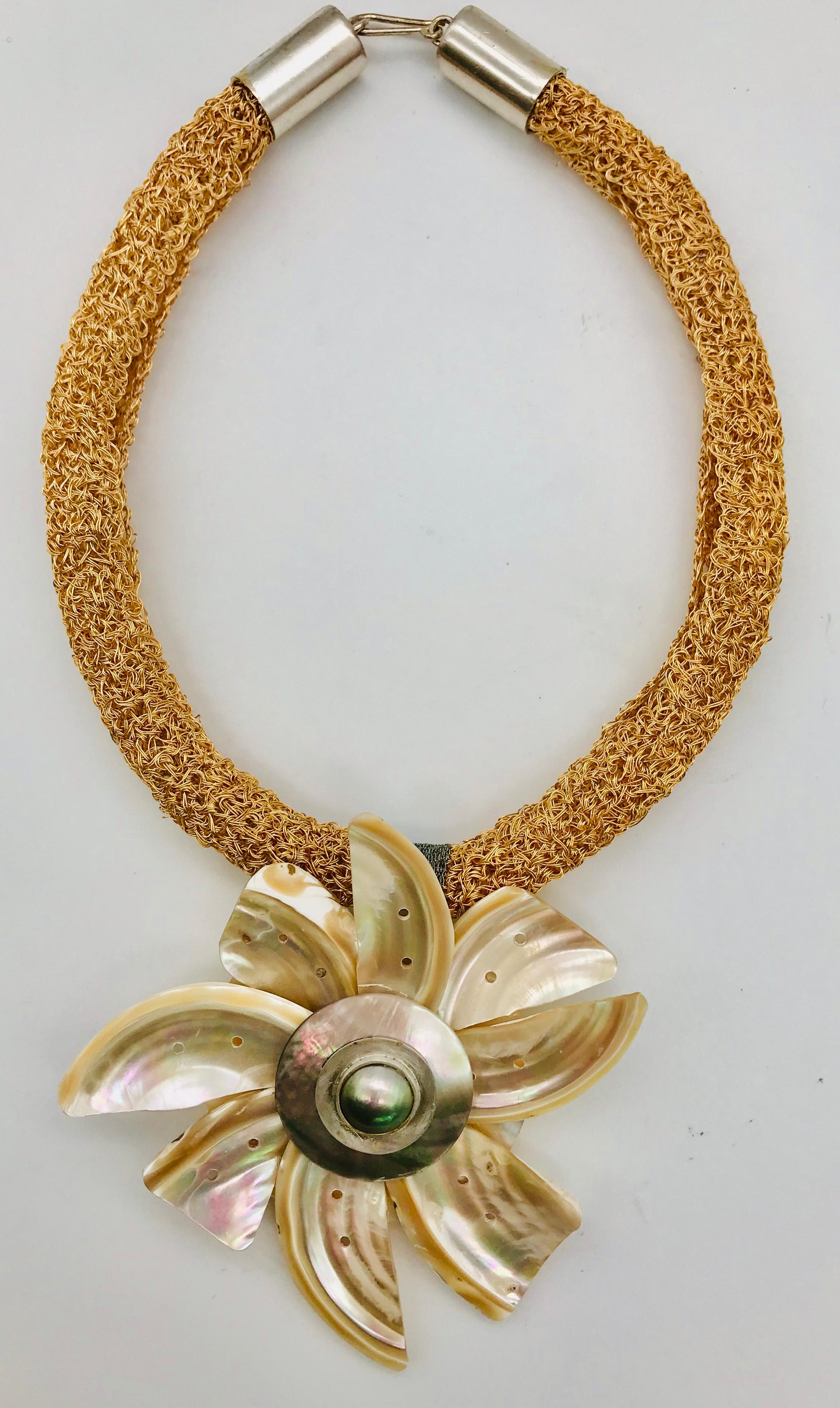 This Pendant is created from iridescent peach color nacre French Deco shell fragments in form of flower petals. The center is made from black nacre circle with black Mabe pearl  framed in silver. The necklace is hand knitted peach color copper wire