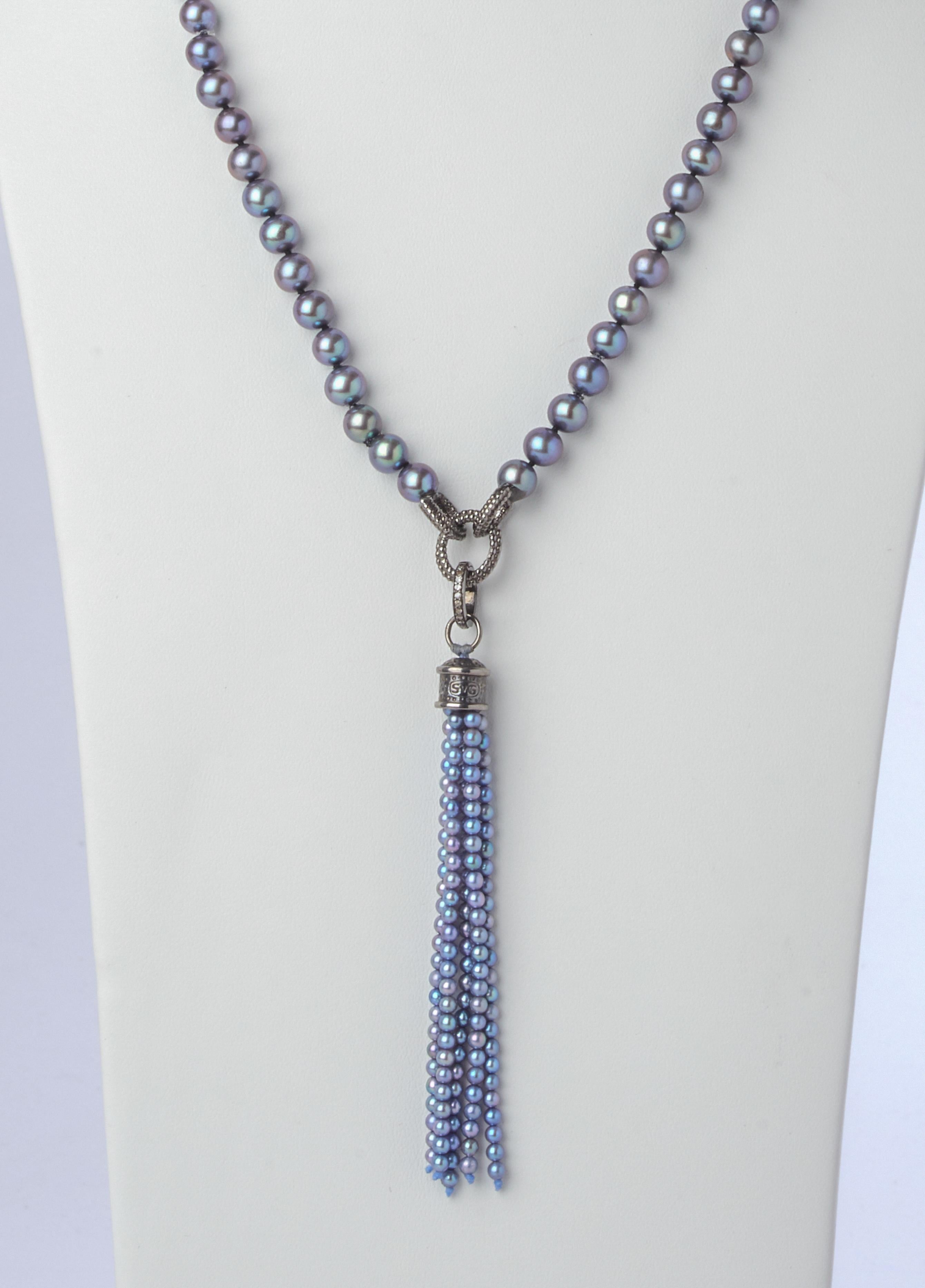 Rich blue, gray and silver tones radiate from this twenty one inch strand of dyed 6-1/2 mm pearls enhanced with two stations of decorative textured silver link chain. Complimenting is a sterling silver and pearl tassel pendant enhancer that is