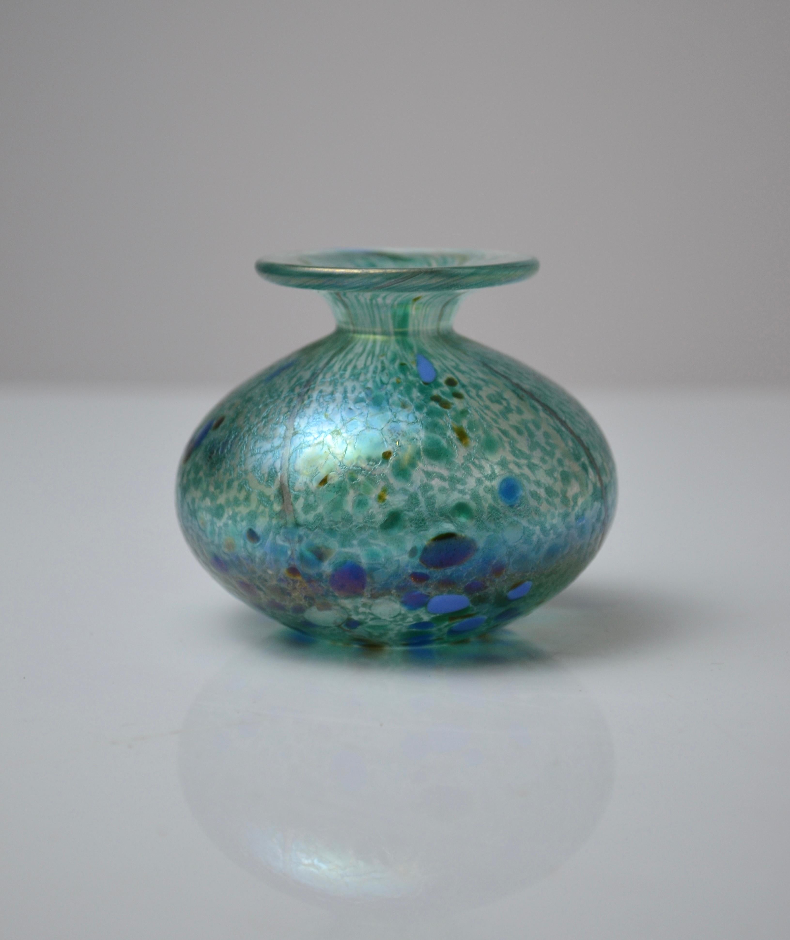Encantador frasco pequeño de perfume de vidrio soplado creado por el conocido estudio Isle of Wight Glass, fundado por Michael Harris en la Isle of Wight en la década de 1970.
Esta pieza presenta un delicado tono verde mar con inclusiones azules y