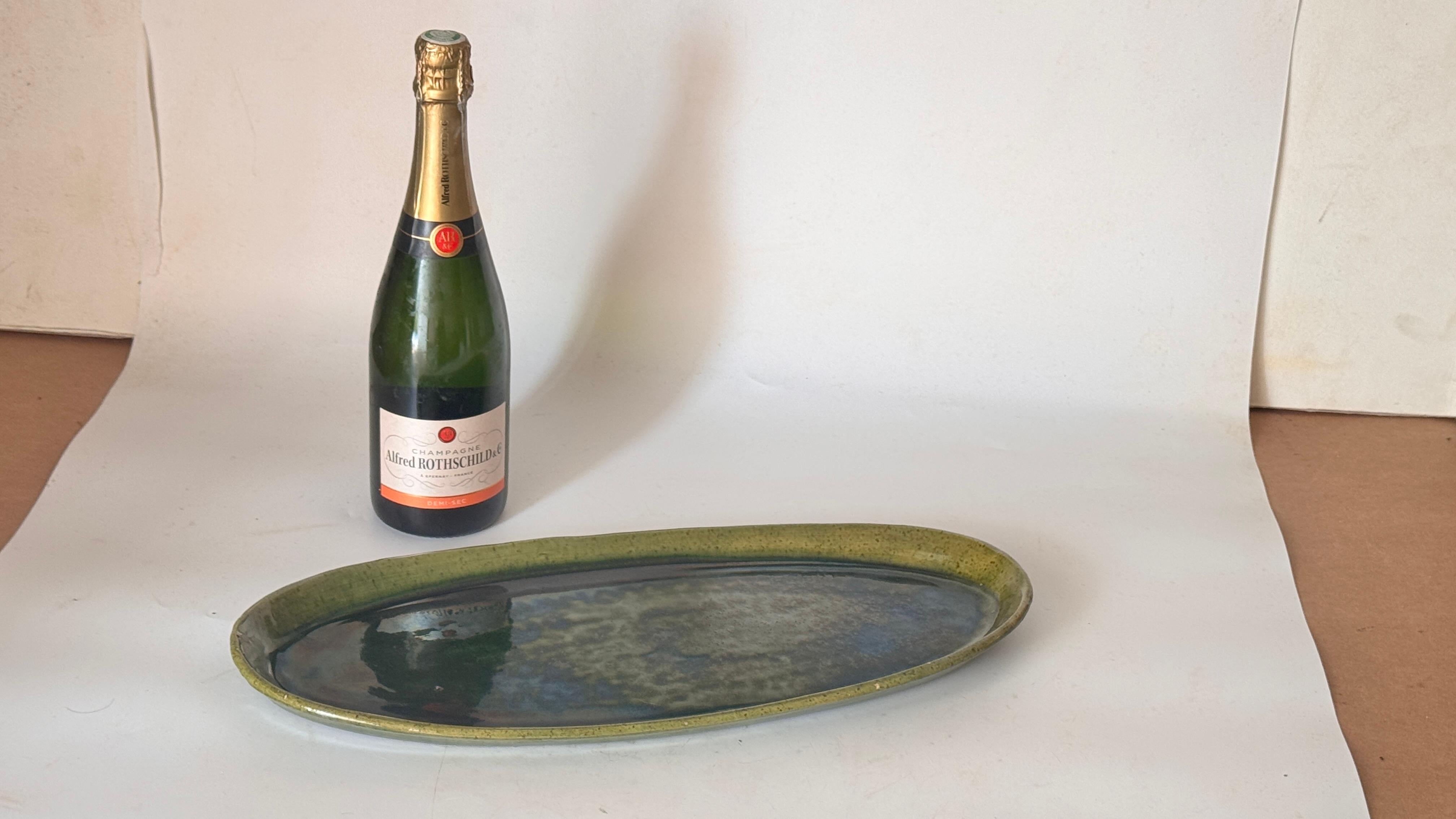 Plat ovale irisé en céramique - France, années 1970

Description :
Il s'agit d'un plat ovale en céramique, de forme légèrement irrégulière, fabriqué en France dans les années 1970. La surface présente une belle glaçure irisée qui change doucement