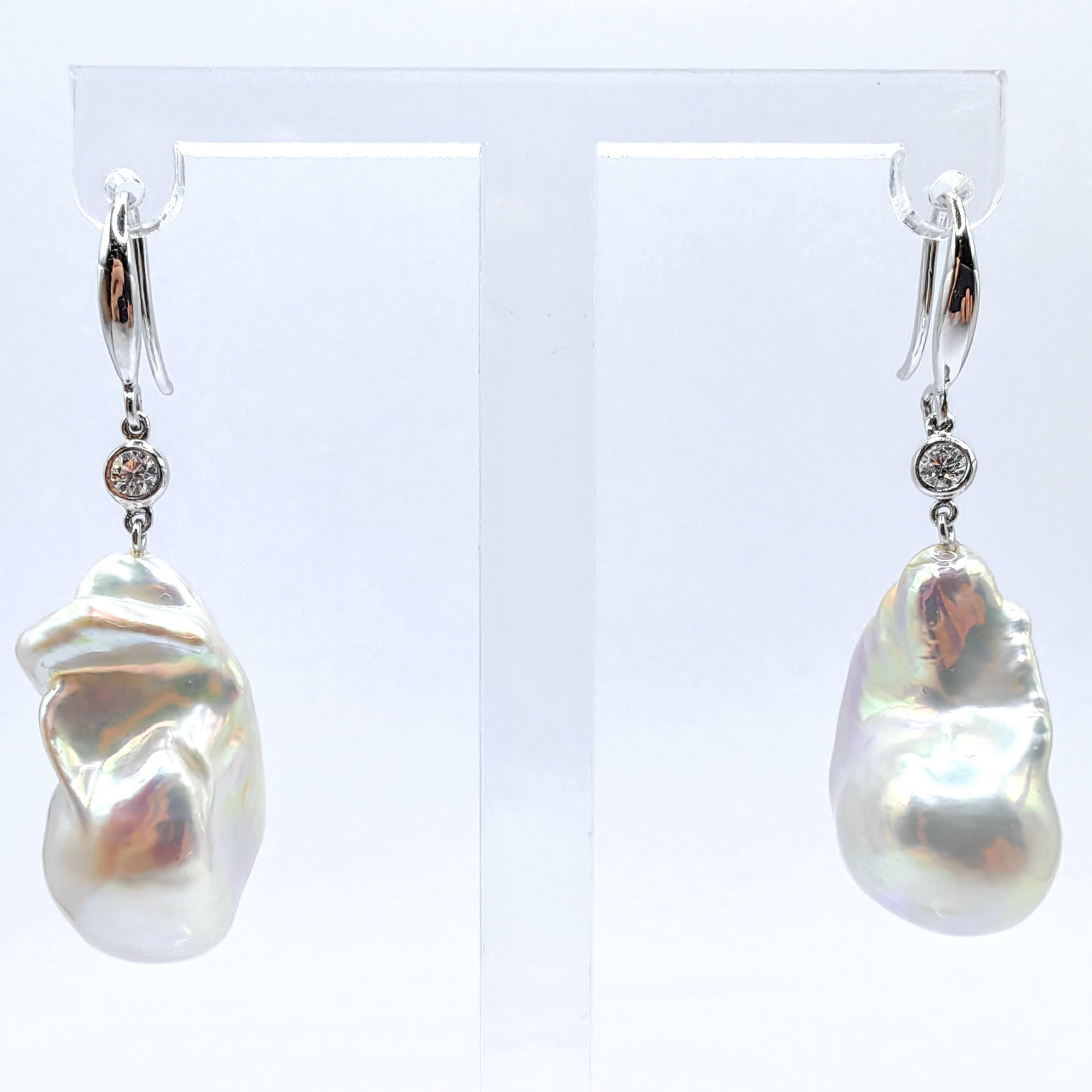 Faites l'expérience d'une élégance raffinée avec nos boucles d'oreilles pendantes en perles baroques blanches métallisées irisées et diamants, où la beauté naturelle rencontre un design sophistiqué. Ces boucles d'oreilles exceptionnelles présentent