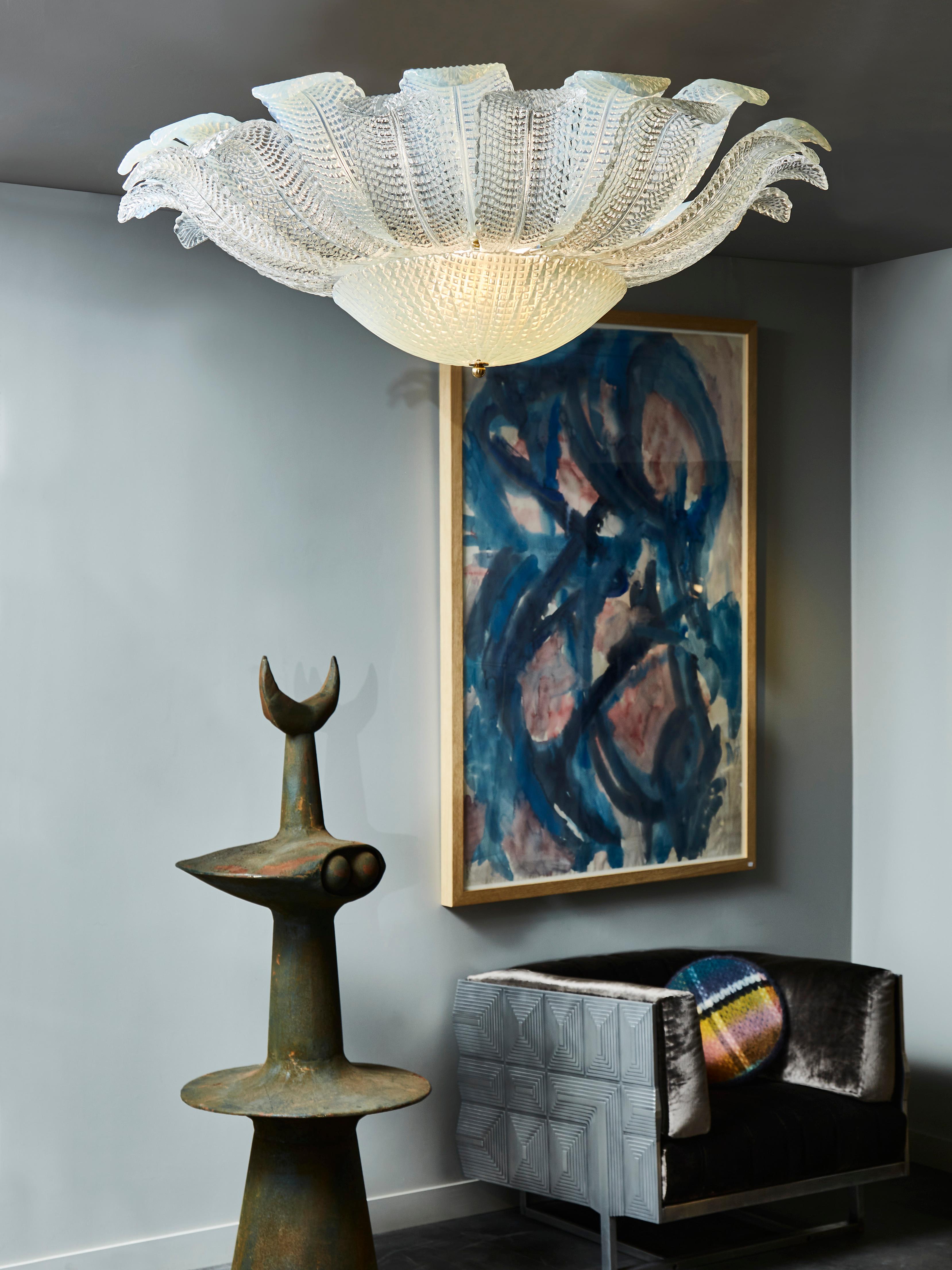 Plafonnier en verre de Murano légèrement irisé, avec un dôme central et des feuilles qui montent vers le plafond.