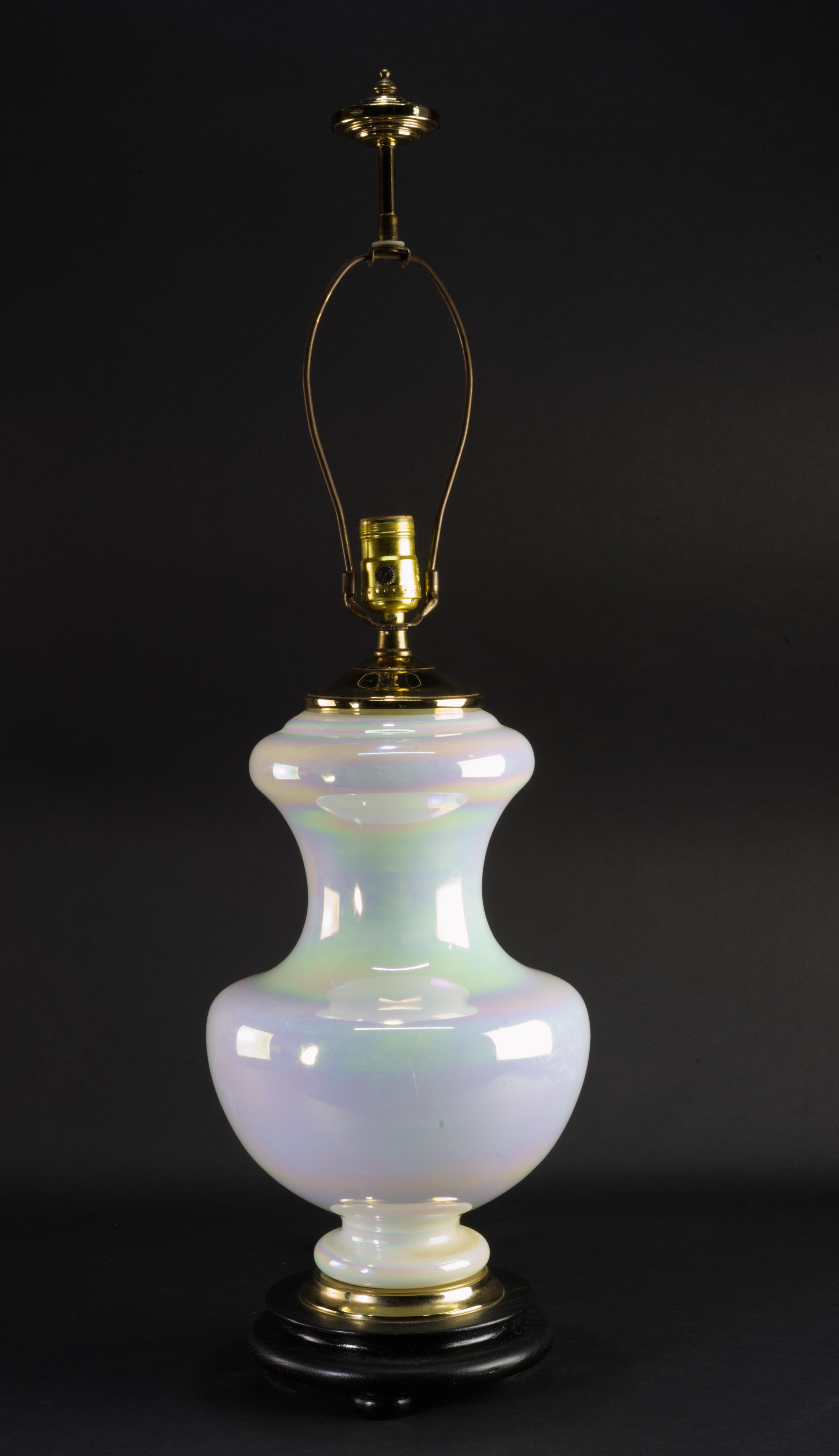 Cette lampe de table est dotée d'un corps en verre irisé, d'une base en bois noir et d'accents en laiton sur le dessus et la base. La forme sculpturale sophistiquée et la finition monochromatique de type perle permettent à la lampe de créer un