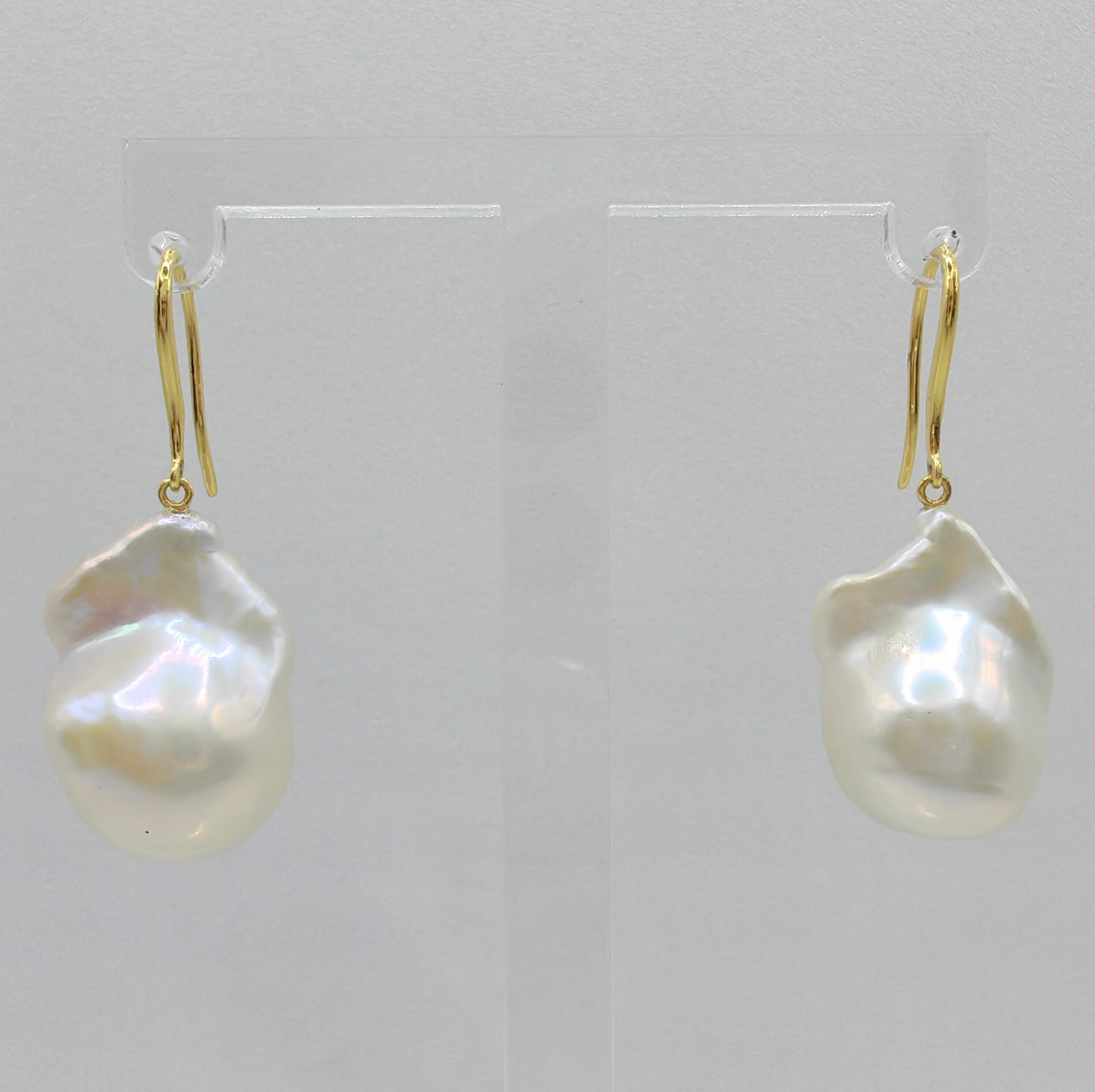 Indulge in the alluring grace of our Iridescent White Baroque Pearl Drop Earrings with 18K Yellow Gold French Hooks, crafted to captivate and inspire. These remarkable earrings feature stunning Freshwater Cultured Baroque Pearls, boasting a