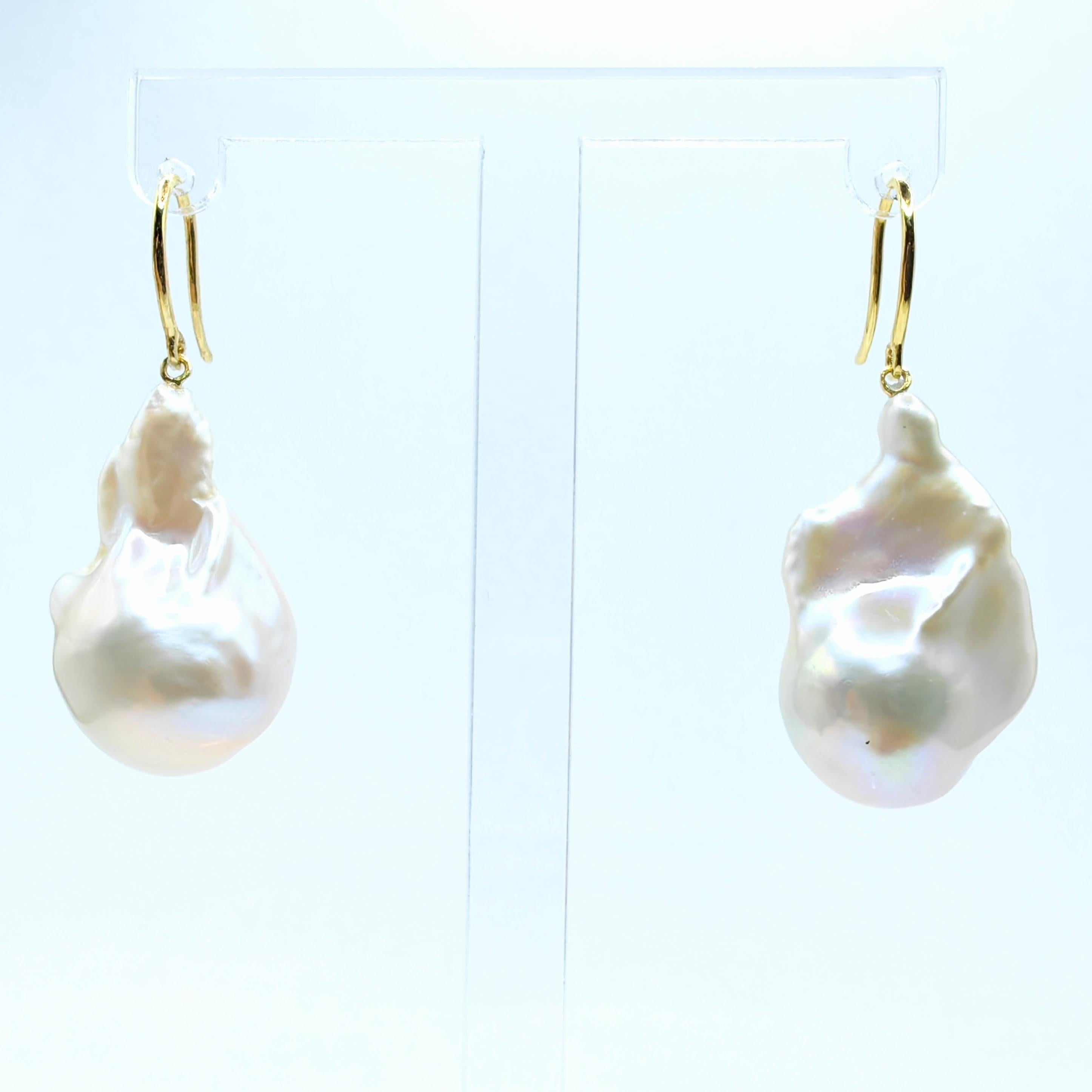 Indulge in the alluring grace of our White Baroque Pearl Drop Earrings, crafted to captivate and inspire. These remarkable earrings feature stunning Freshwater Cultured Baroque Pearls, boasting a brilliant white hue with a delicate iridescent glow.