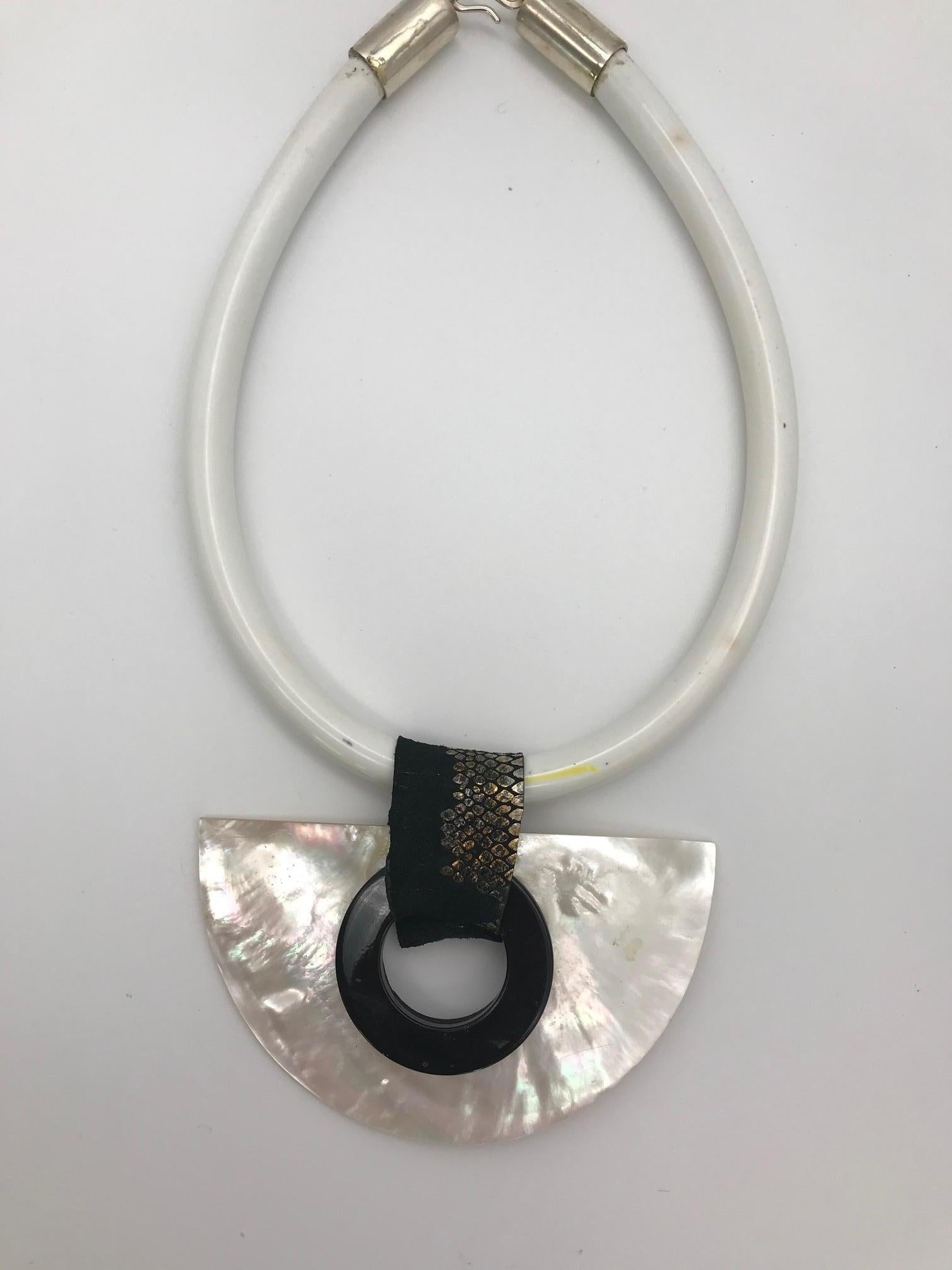 
Mother of Pearl Pendant , white  is eco-luxe and sustainable The materials used are iridescent mother of pearl/nacre, called Pinctada Maxima, which is shown in the last image. The White Moon pendant has a black resin circle on one side and a rubber