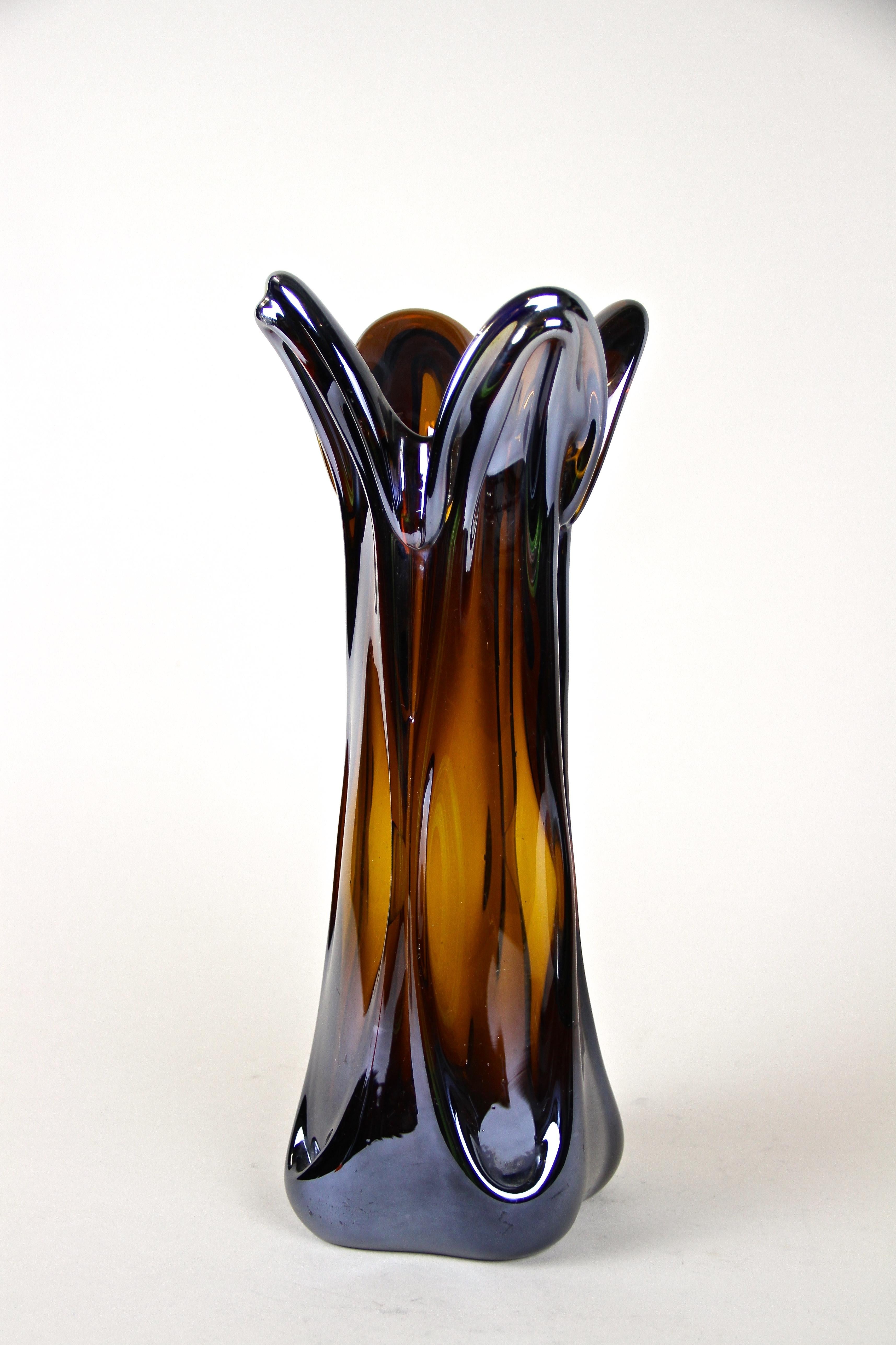 Extraordinary handcrafted Murano glass vase from the late 20th century around 1970 in Italy. This fantastic looking glass vase shows an unusual shaped, amber-colored body with exceptional chrome effect. The highly iridescent surface reflects the