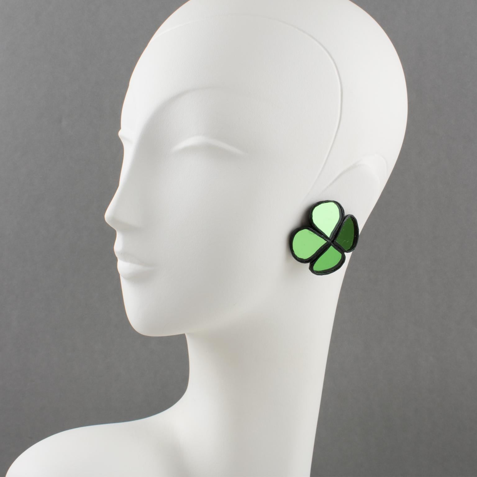 Beautiful Talosel or resin clip-on earrings designed by Irena Jaworska in the 1970s. They feature a geometric four-clover shape in black resin framing, topped with green mirrors. Irena Jaworska is one of the students of the Line Vautrin school,