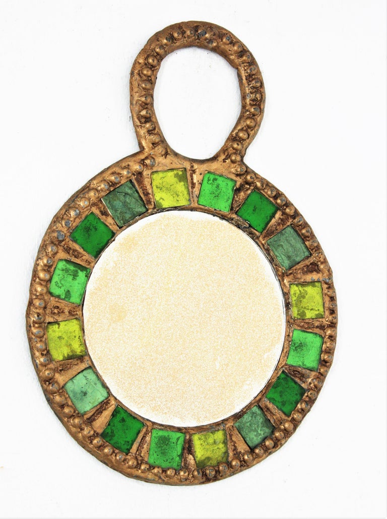 Metal wall mirror or hand mirror with green glass inlays atrributed to Irina Jaworska ( Line Vautrin School ), France 1970s.
Lead framed gilt mirorr with pressed pattern and glass inlays in shades of green surrounding a round golden mirror.
Irina