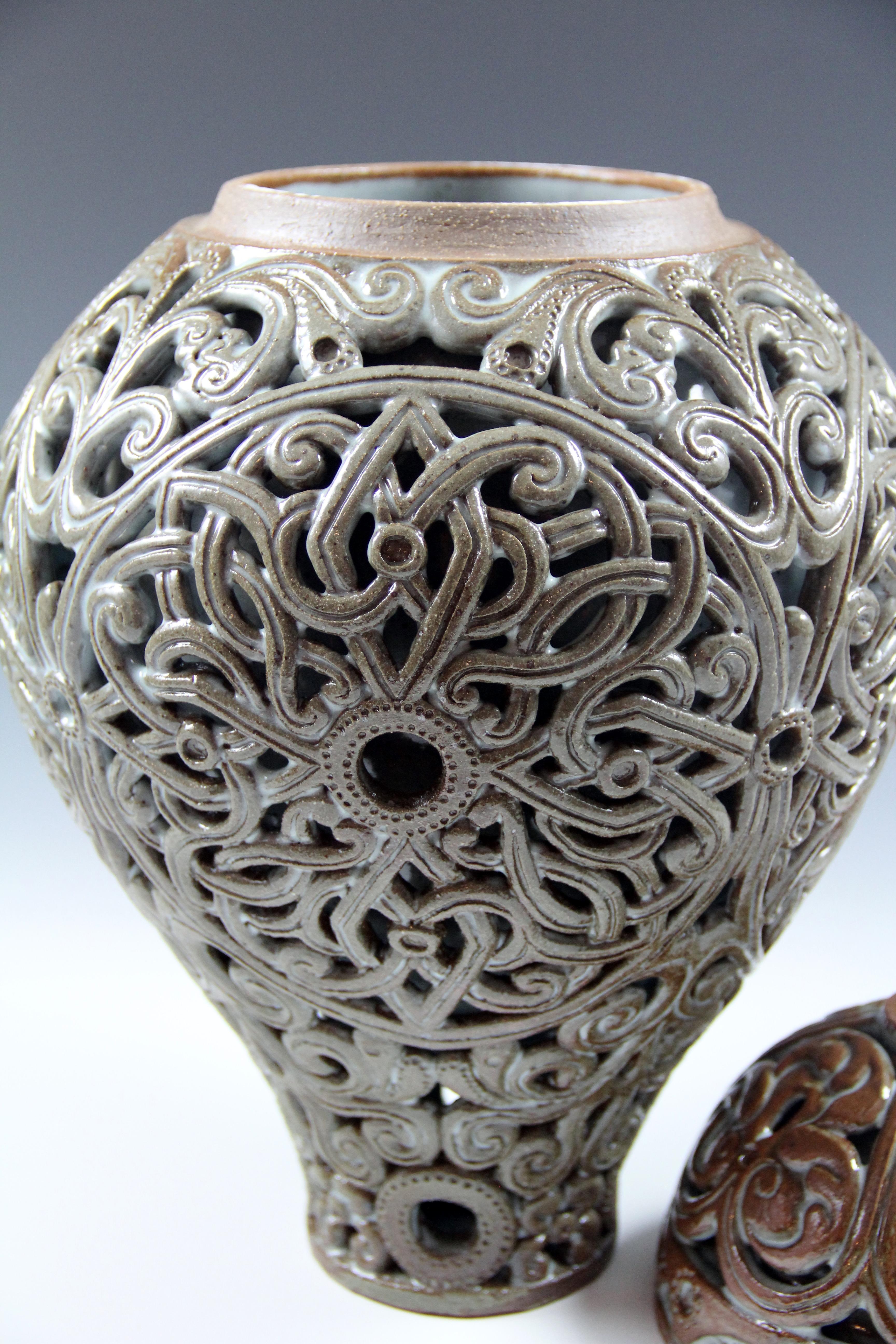 This is double-wall carved ceramic urn. All parts of it were thrown on a pottery wheel, then attached together and hand carved, glazed and fired. 
 
 Irina Deshchenko-Lakshin was born and raised in Petropavlovsk-Kamchatsky, the capital of the