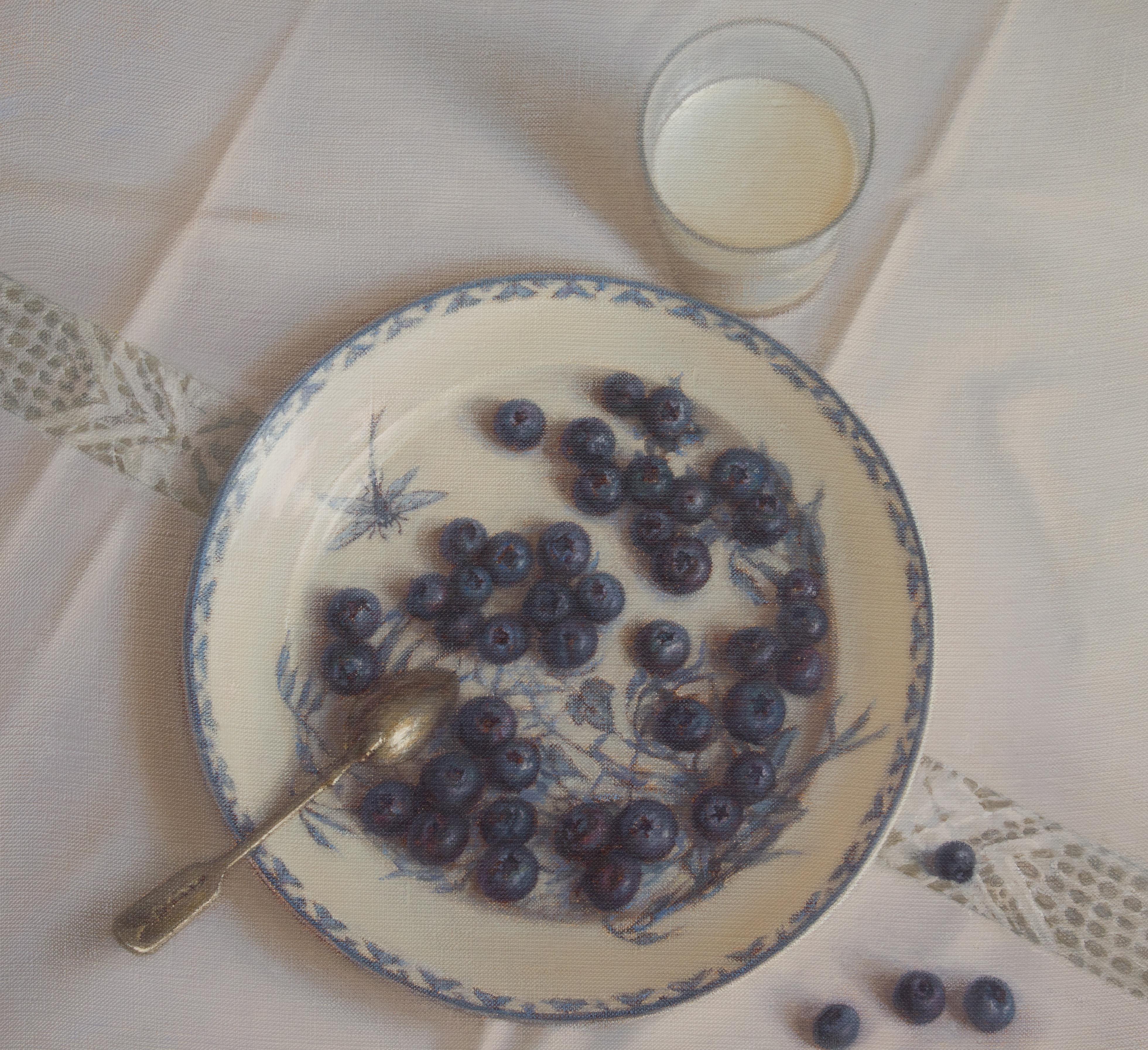 Cette charmante nature morte de petit-déjeuner présente des myrtilles fraîches servies dans une assiette ornée de motifs bleus et blancs, accompagnées d'un verre de lait. La composition est posée sur une nappe blanche ornée d'une délicate dentelle,