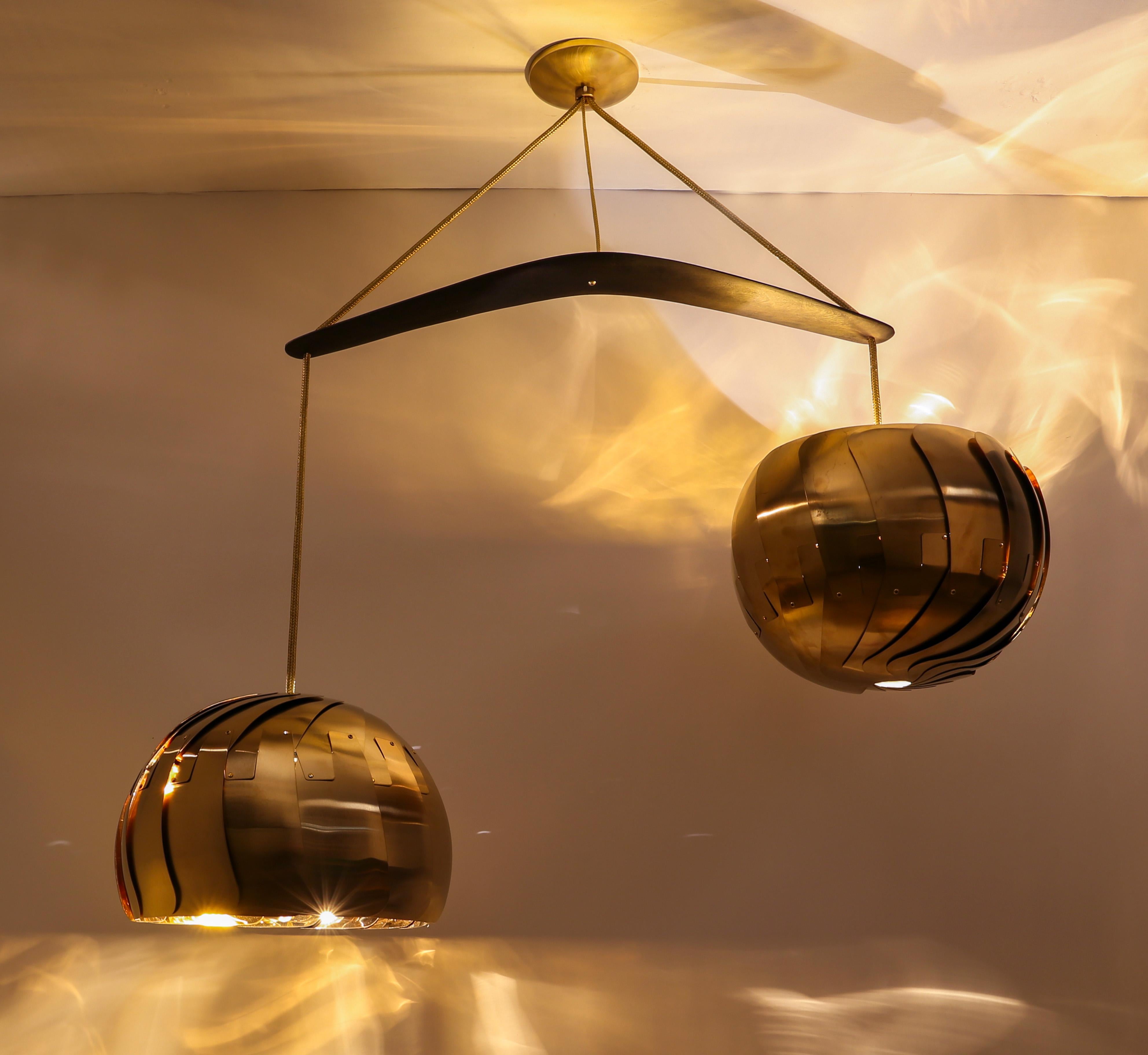 IRIS BALANCE • Lustre moderne en laiton  Pendentif à deux lumières • Luminaires sculpturaux

Le lustre Iris Balance est composé de deux abat-jour Iris qui s'équilibrent sur un Boomerang en bois australien teinté noir. Chaque abat-jour peut être