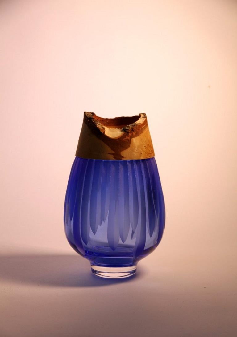 Iris blue Frida with cuts stacking vessel, Pia Wüstenberg
Dimensions: D 13 x H 20
Materials: cut glass, wood

With its sculpted glass topped by Curly Birch, Poppy is an exquisite vessel. This delightful piece finds heritage in the refined skills