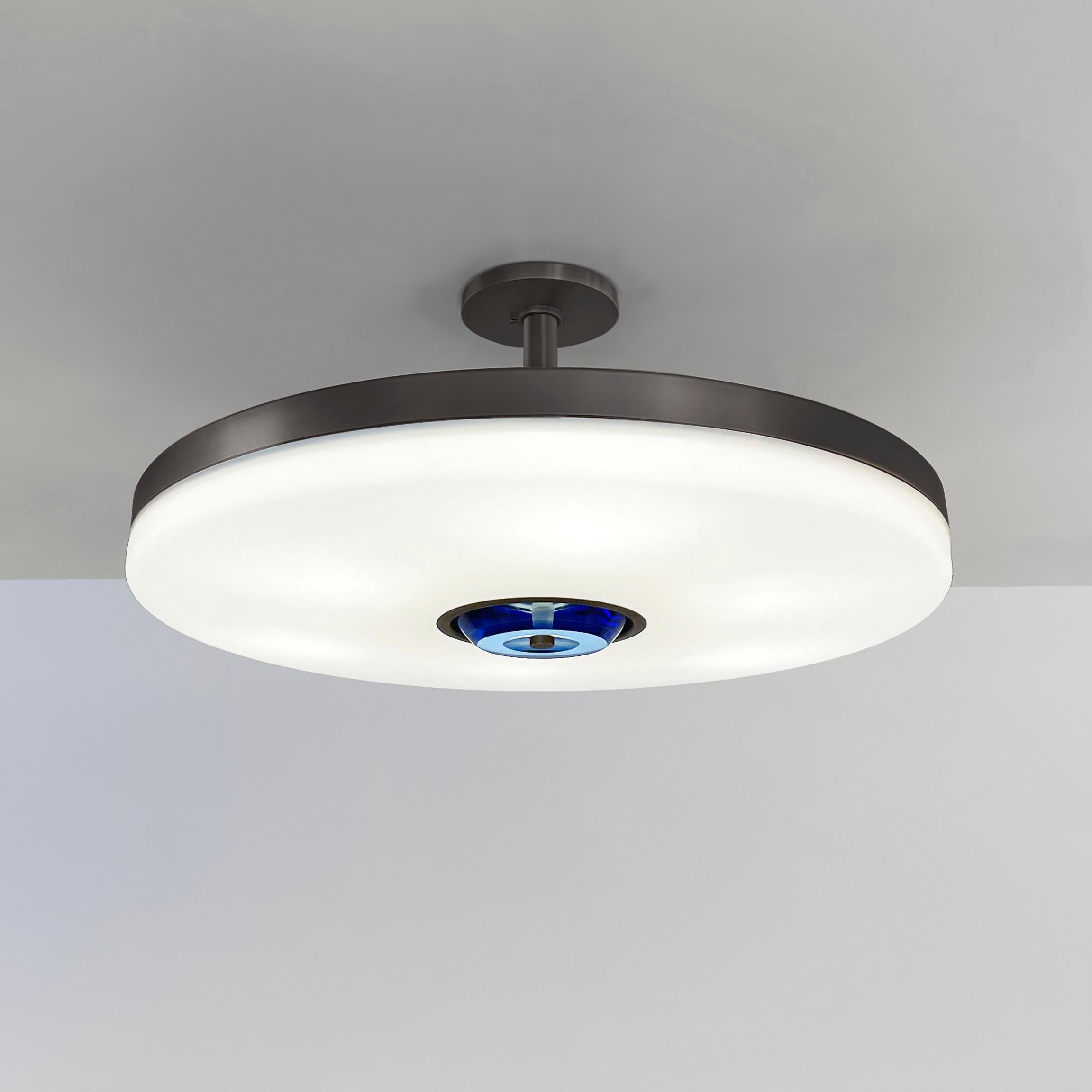 The Iris ceiling is designed around an expansive acrylic shade with a hand carved glass center. This versatile fixture can be installed as a pendant on a stem or as a true flush mount. The first images show the fixture in our Brunito Nero (black