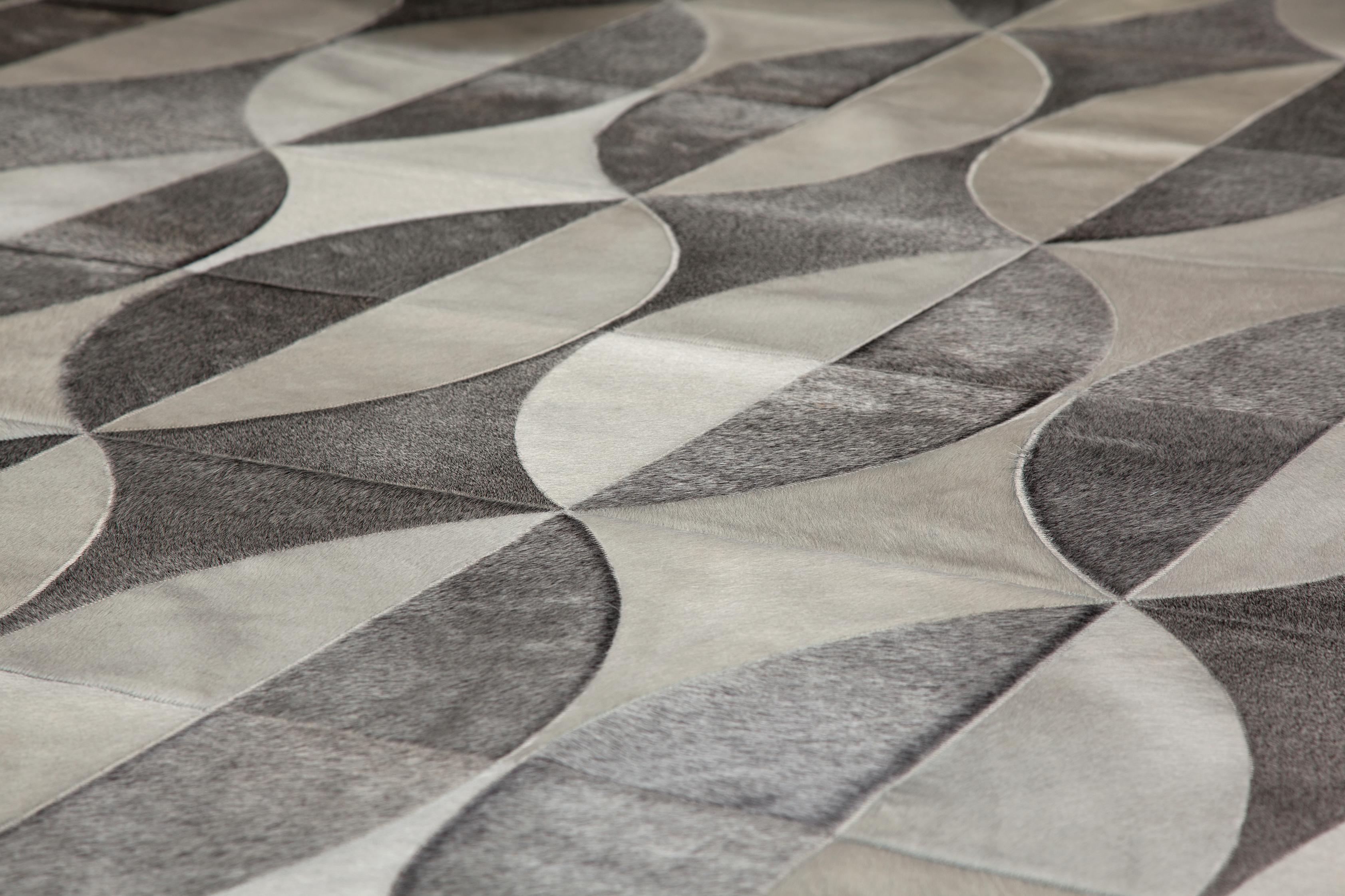 The Iris design uses curved, symmetrical lines with varying sets of color repetition to create a rug that is both visually engaging and sophisticated. Made with heather grey and white cowhides, the Iris features our two of our most exclusive cowhide