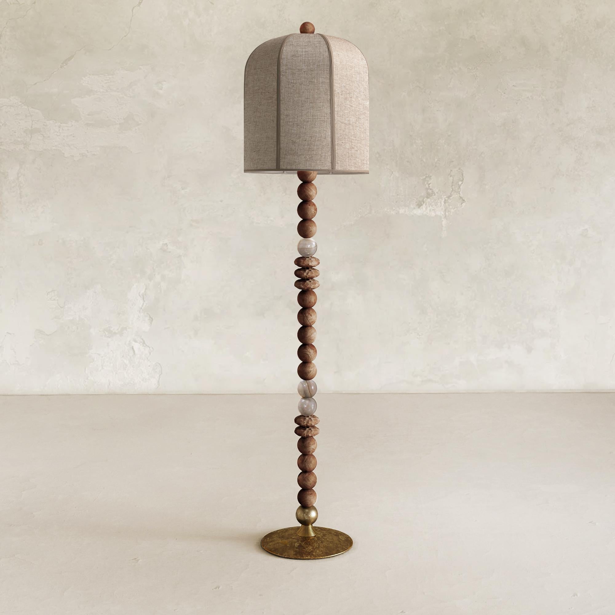 The Iris Floor Lamp is a handcrafted lighting fixture, which incorporates solid wood, alabaster, and liquid bronze to create a unique appearance. Traditional techniques such as casting and hand sculpting are used in its creation, and each piece is