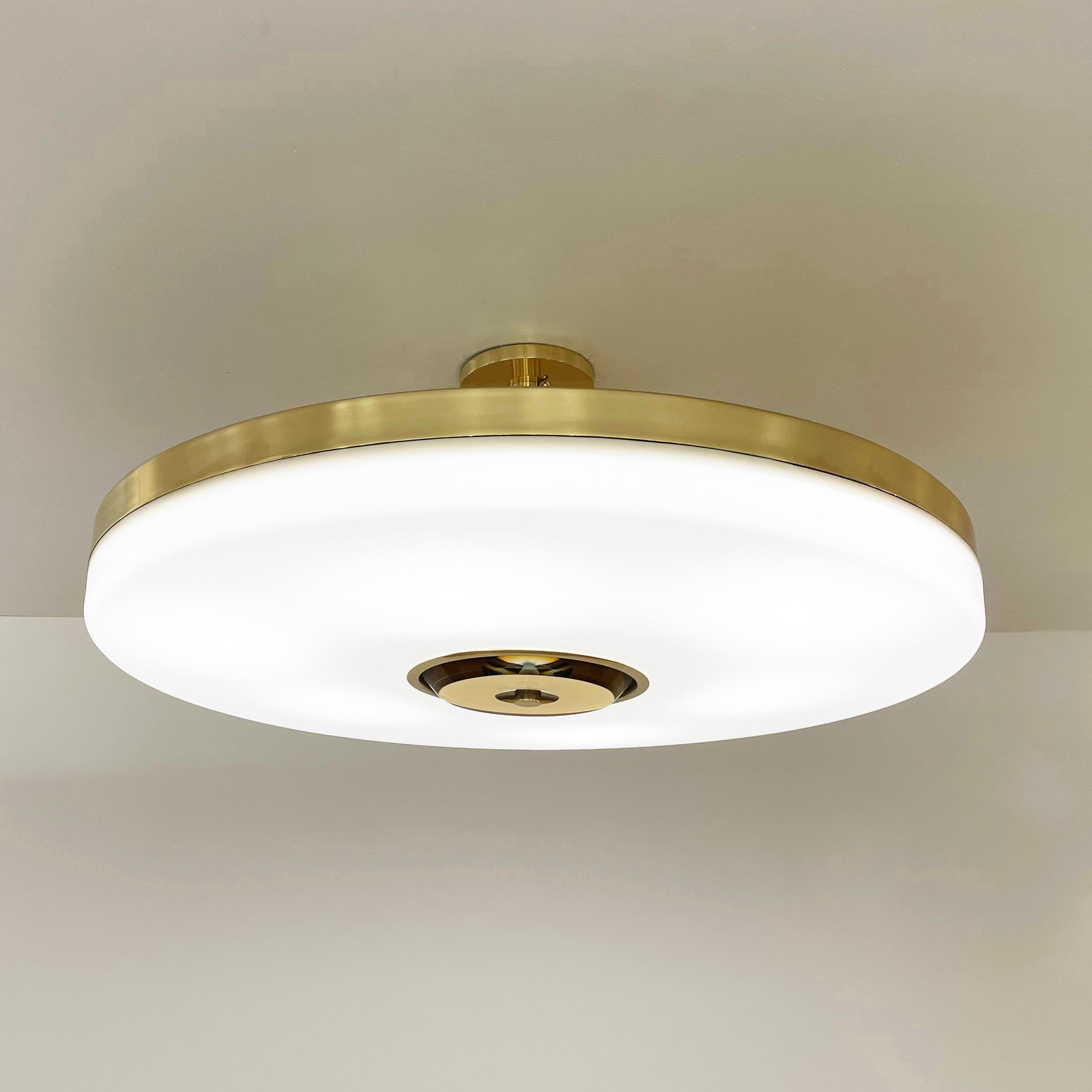 The Iris ceiling light is designed around an expansive acrylic shade with a hand carved glass center. This versatile fixture can be installed as a pendant on a stem or as a true flush mount. The first images show the fixture in our polished brass