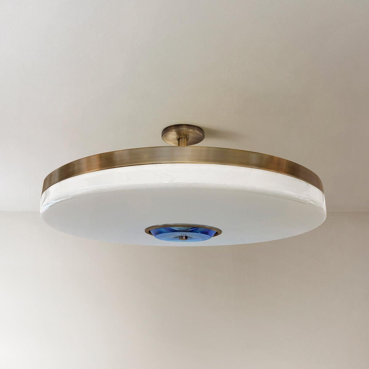The Iris ceiling light is designed around an expansive acrylic shade with a hand carved glass center. This versatile fixture can be installed as a pendant on a stem or as a true flush mount. The first images show the fixture in our Bronzo Ottone