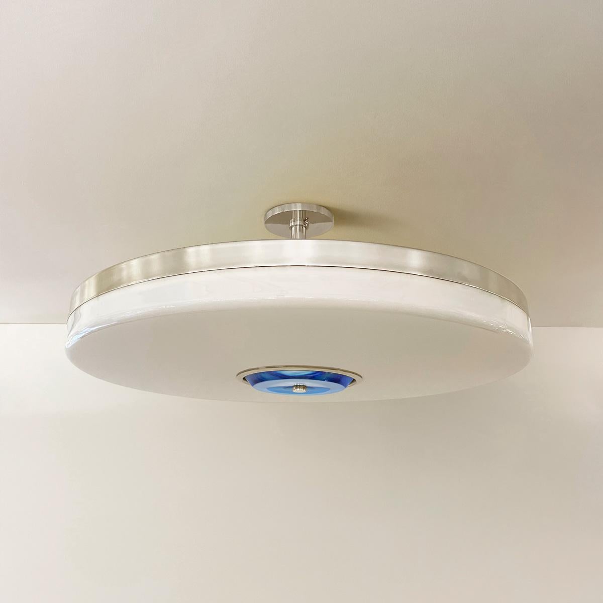 The Iris ceiling light is designed around an expansive acrylic shade with a hand carved glass center. This versatile fixture can be installed as a pendant on a stem or as a true flush mount. The first images show the fixture in our polished nickel