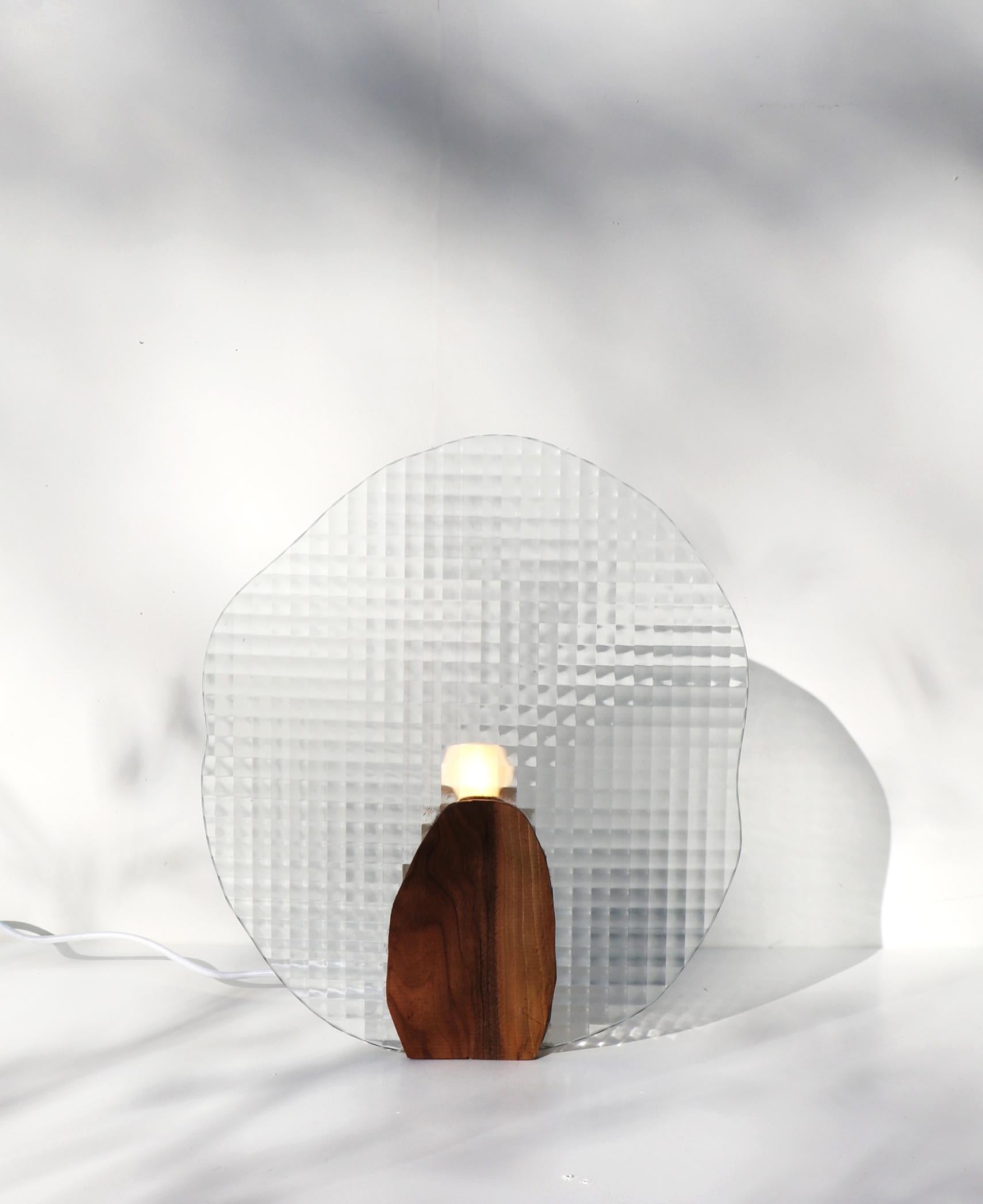 Iris lamp by Alice Lahana Studio
Dimensions: W 37 x D 5 x H 43 cm
Materials: walnut, glass, varnish

The Iris lamp can be seen from the front or from the back. It evolves throughout the day according to the rays of light that cross its