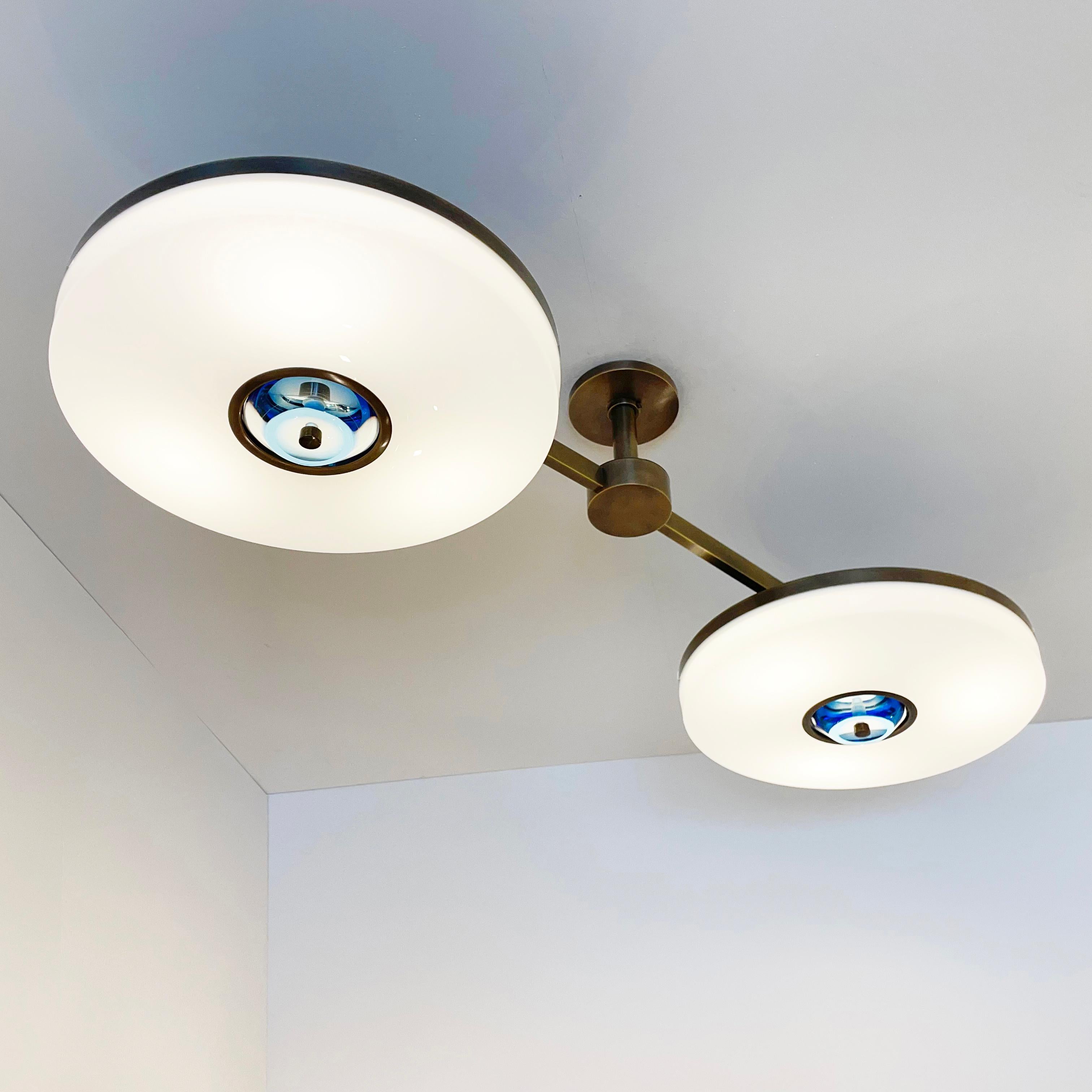 The Iris N.2 ceiling light is designed around two expansive acrylic shades with hand carved glass centers. This versatile fixture can be installed on a stem or as a flush mount. Ideal over kitchen islands, dining tables and other elongated spaces.