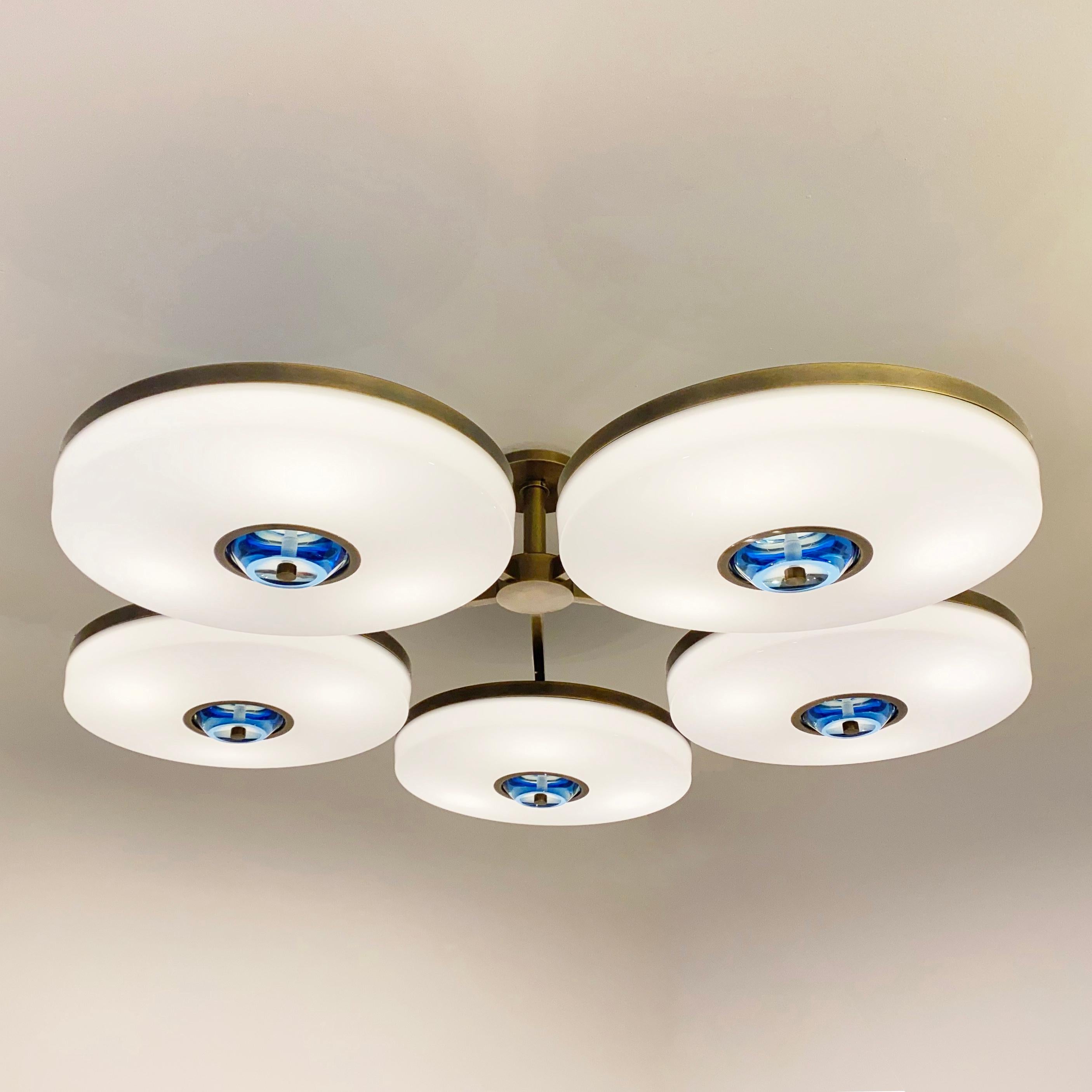 The Iris N.5 ceiling light is designed around five expansive acrylic shades with hand carved glass centers. This versatile fixture can be installed on a stem or as a flush mount. The first images show the fixture in our Bronzo Ottone (bronze)