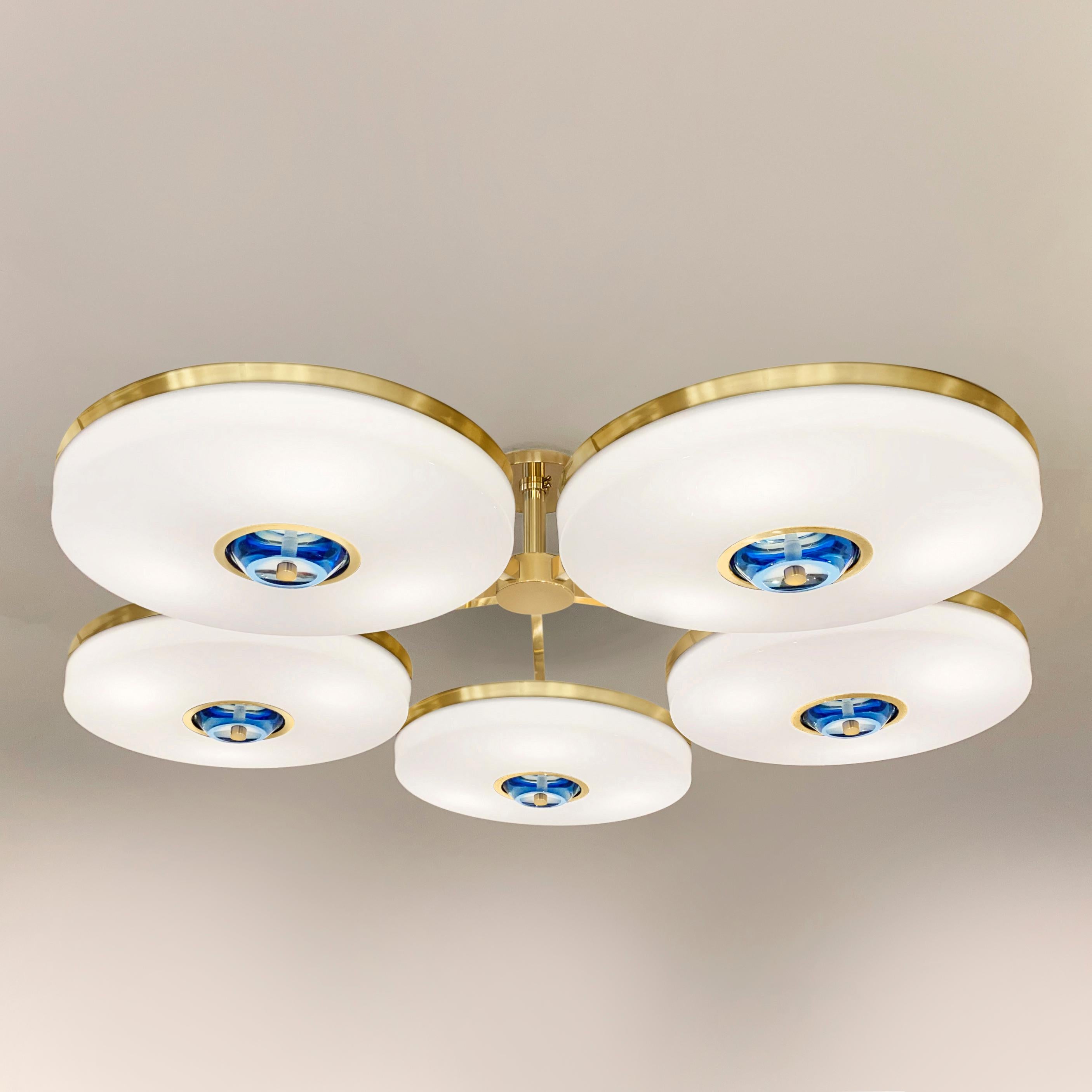 The Iris N.5 ceiling light is designed around five expansive acrylic shades with hand carved glass centers. This versatile fixture can be installed on a stem or as a flush mount. The first images show the fixture in our polished brass