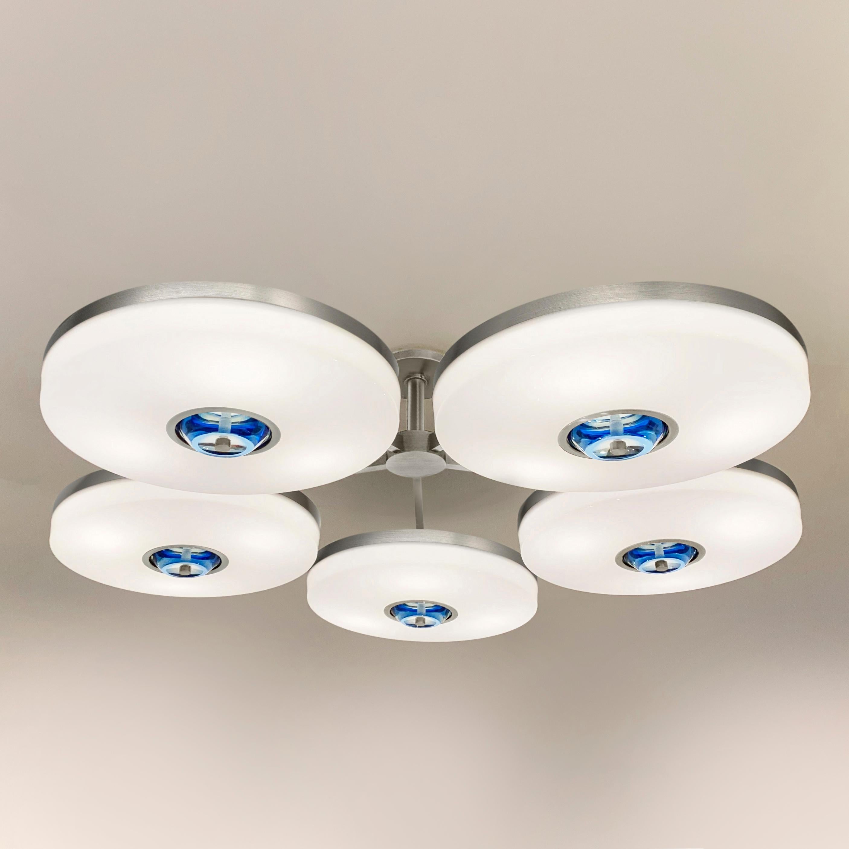 The Iris N.5 ceiling light is designed around five expansive acrylic shades with hand carved glass centers. This versatile fixture can be installed on a stem or as a flush mount. The first images show the fixture in our satin nickel