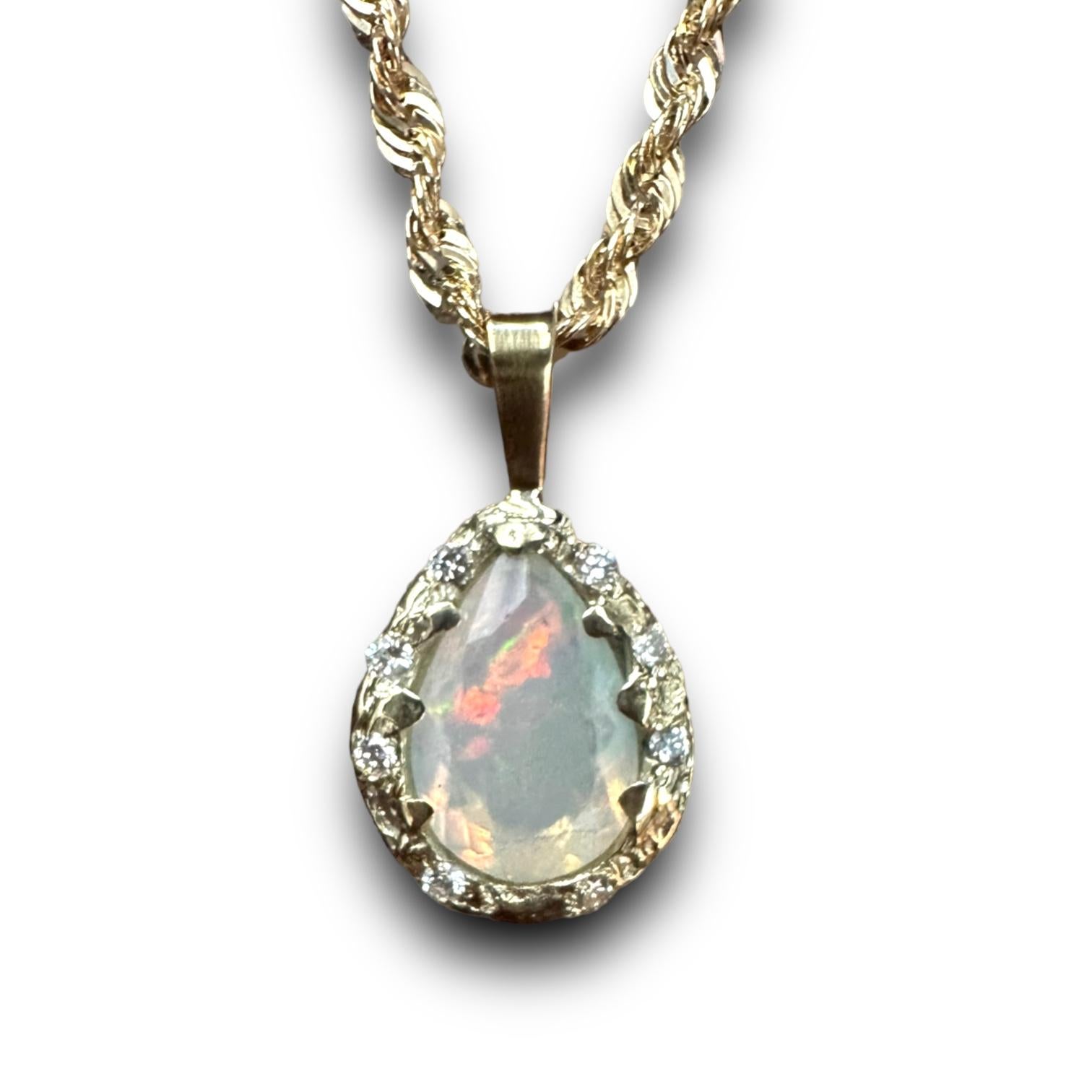Voici Iris, notre collier de corde en opale magique avec diamants en or jaune 14k, unique en son genre ! Ce bijou exquis ne manquera pas d'attirer l'attention de tous par sa beauté envoûtante. Le collier comporte une superbe goutte d'opale qui a été