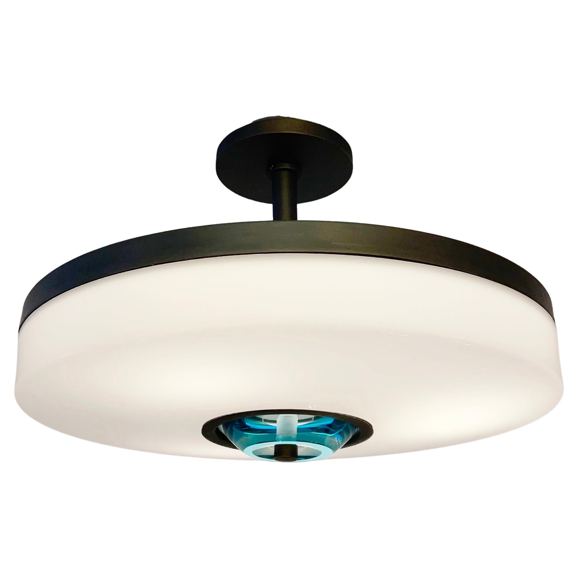 The Iris Piccolo ceiling light is designed around an expansive acrylic shade with a hand carved glass center. This versatile fixture can be installed as a pendant on a stem or as a true flush mount. Shown in our Brunito Nero finish. Price listed for