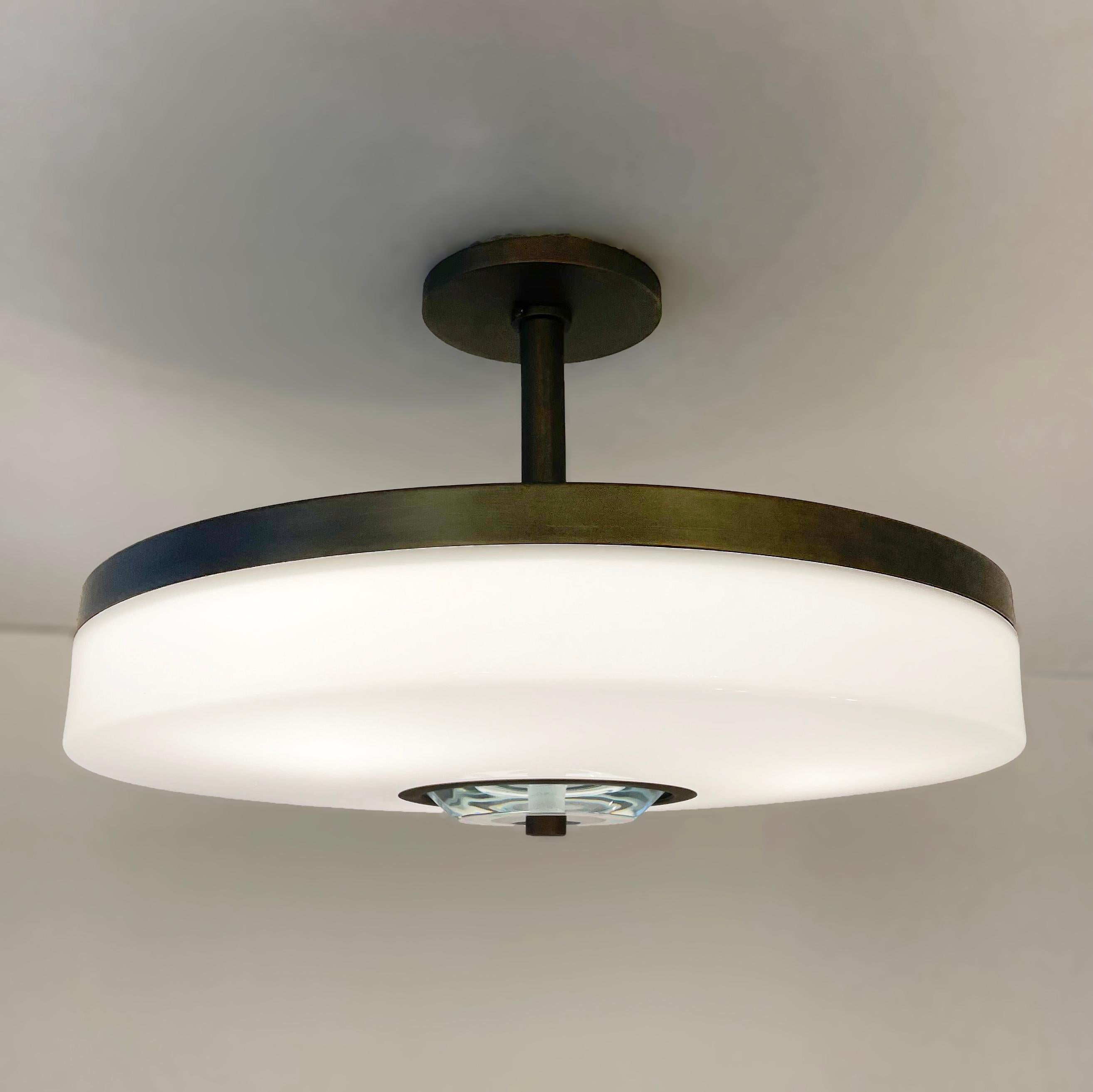 The Iris Piccolo ceiling light is designed around an expansive acrylic shade with a hand carved glass center. This versatile fixture can be installed as a pendant on a stem or as a true flush mount. Shown in our Brunito Nero finish. Price listed for