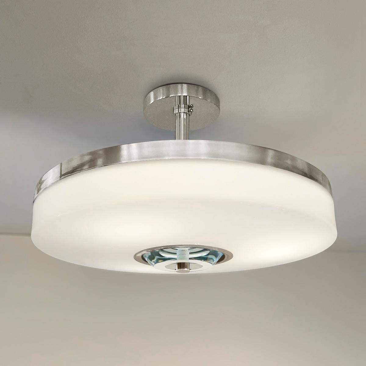 The Iris Piccolo ceiling light is designed around an acrylic shade with a hand carved glass center. This versatile fixture can be installed as a pendant on a stem or as a true flush mount. The first images show the fixture in our polished nickel