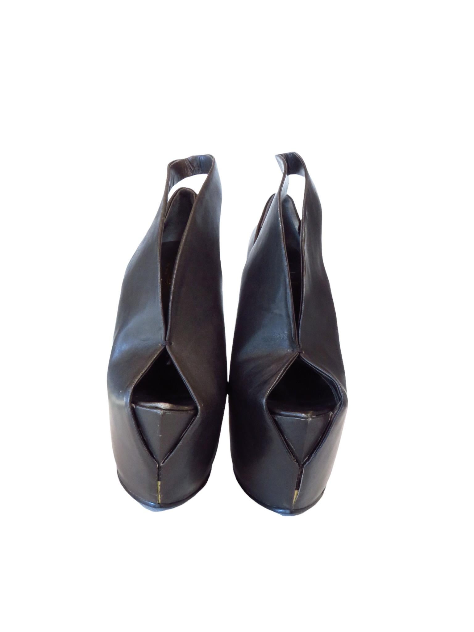 La bottine peptone de Biopiracy repose sur un talon compensé en porte-à-faux. Le cuir moulé noir enveloppe le pied pour sculpter une silhouette futuriste unique. 