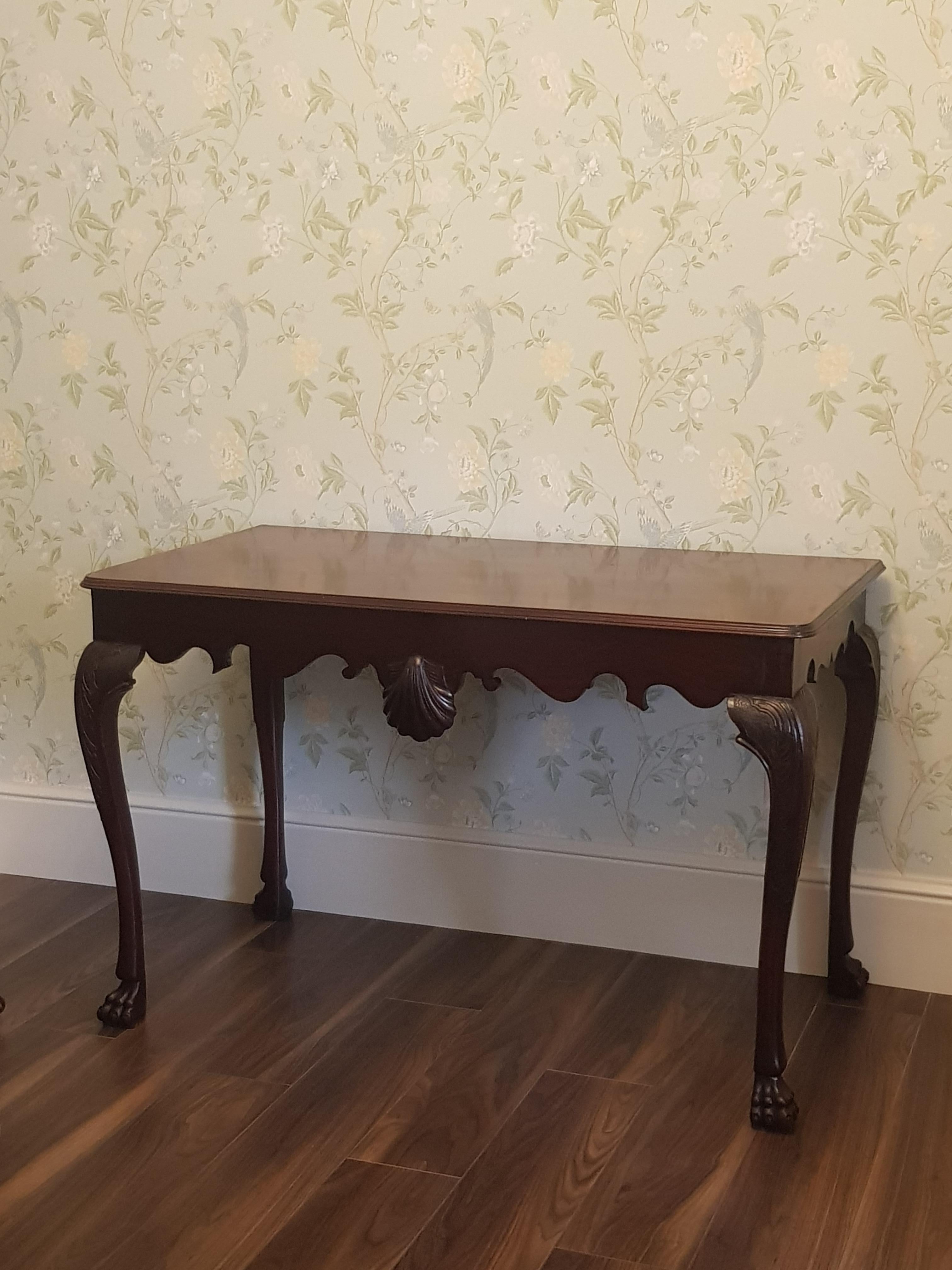 A finely carved Irish mahogany side table attributed to the renowned 19th century Irish Dublin cabinet maker James Hicks, with molded rectangular top, above a shaped apron, centred by a large Venus shell, on Acantus molded cabriole legs, on square