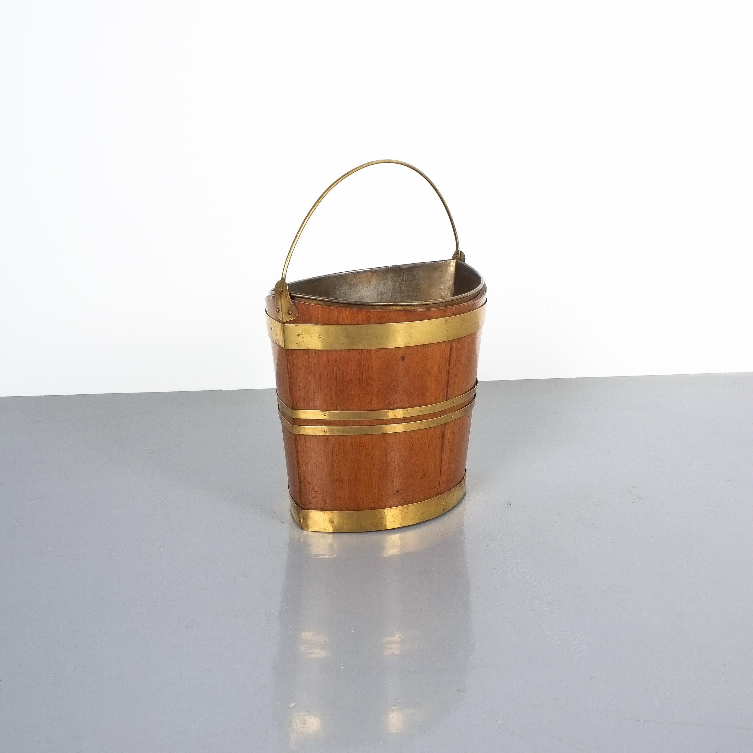 Irish 19th century oval oak brass peat bucket. Beautiful bucket that would make for an interesting waste paper bin or wine cooler or planter or the like. The brass insert is smaller than the wooden bucket.