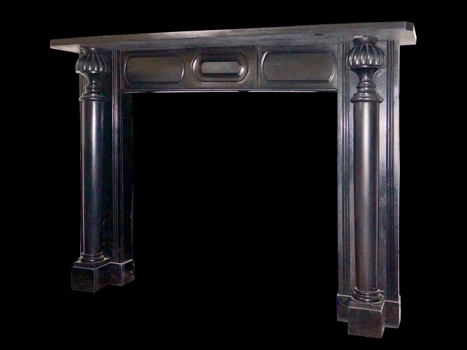 An unusual, rare and early 19th century Irish fireplace in black Kilkenny Marble. The fully disengaged columned jambs with balustrade end blocks, and double moulded panels behind. The frieze with a cushion centre plaque flanked by fielded panels.