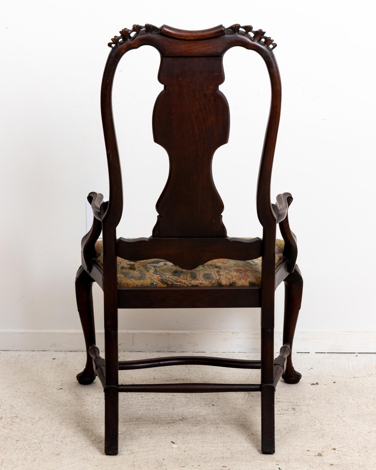 Irish Queen Anne style armchair with upholstered seat and cabriole legs. The piece also features carved, pierced floral trim on the corners of the molded top rail, a pierced back splat, and carved scallop shellwork on the front of the seat rail.