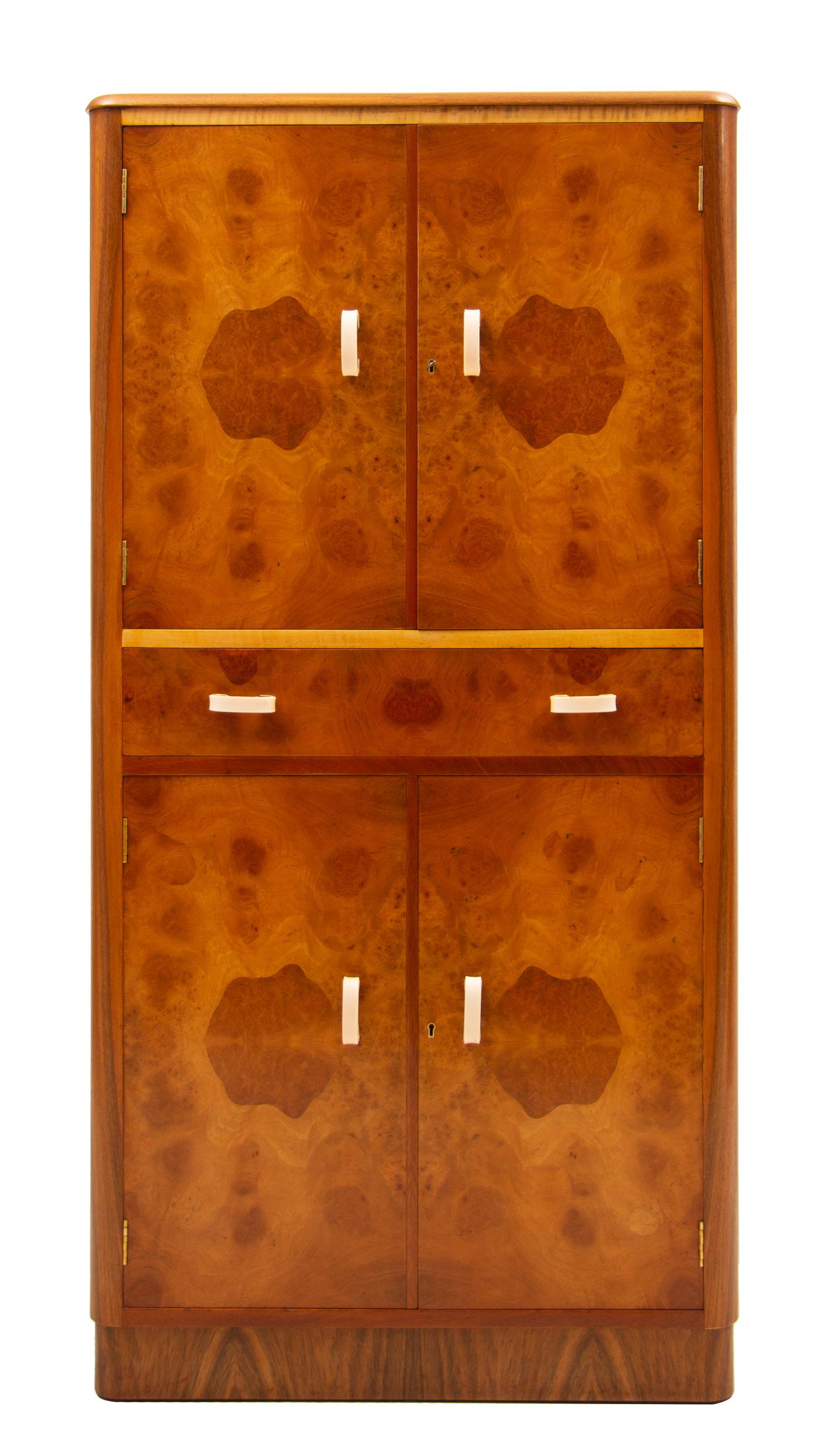 Art Deco cocktail cabinet in bird's-eye maple and walnut.
Upper section with internal glass shelves and mirrored back
Mirrored slide for cutting lemons and limes
Single drawer above lower cupboard with two doors
Measures: H 153 cm, W 77 cm, D 51