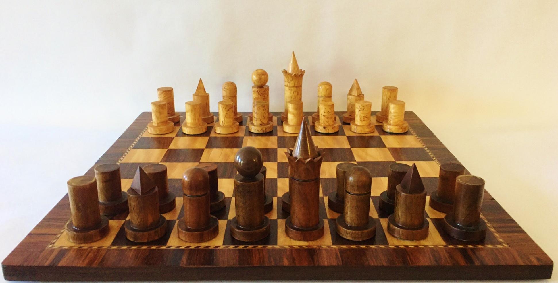 This stunningly hand-crafted, all original, Irish Art Deco chess set features a board with inlaid squares of light and dark finely grained wood surrounded by a dark rope patterned inlaid wood border and edged in a one inch wide, cross-banded, dark