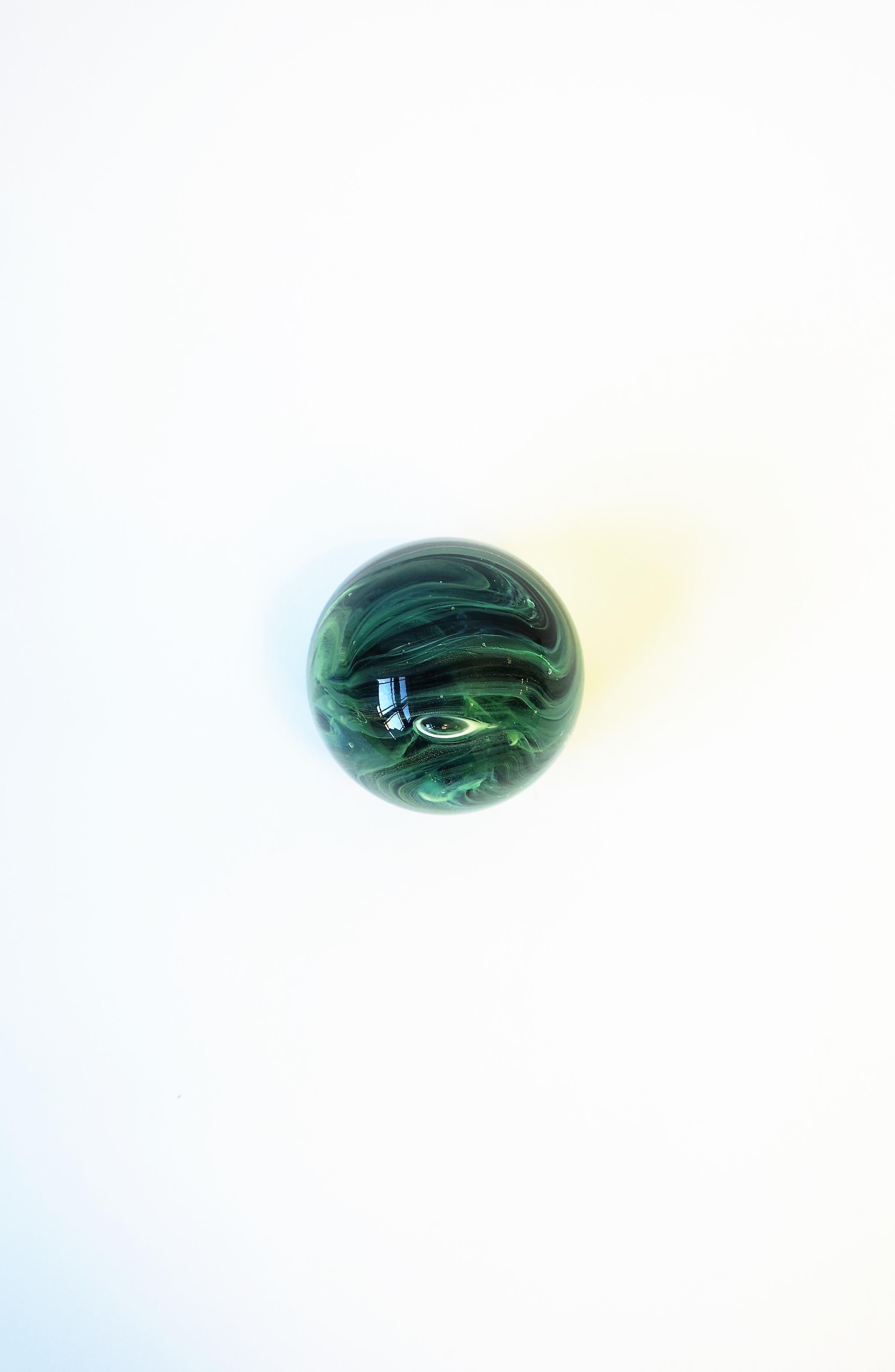 A very beautiful Irish art glass paperweight sphere or decorative object in several shades of green, circa late-20th century, Ireland. Piece is hand-blown swirls of clear/transparent and shades of green (Emerald, dark, Kelly, light) art glass. A