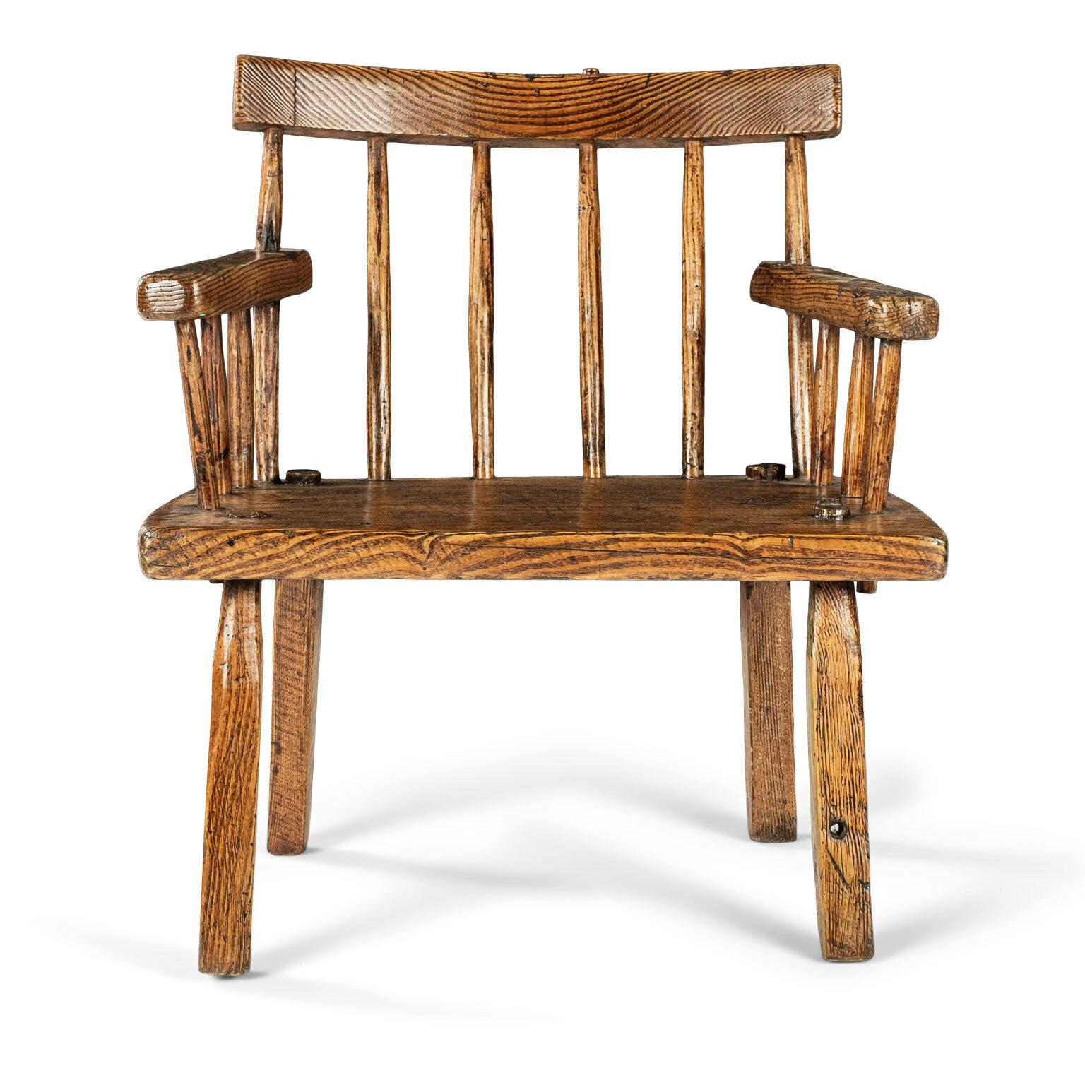 Irish ash comb back armchair dating to the 19th century. Curved top rail, carved stick back, splayed arms, wedge seat and splayed squared legs. Traces of early blue-green paint under seat. All joints tightened. Very sturdy and stable. Perfect
