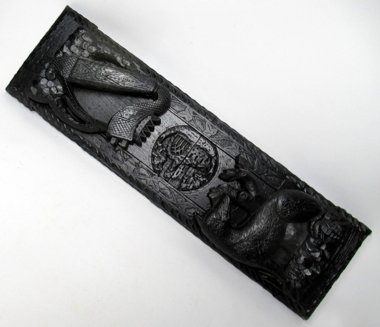 An extremely rare Irish hand carved bog oak book slide of good size proportions, mid-19th century, of outstanding quality and condition. The adjustable base with allround Laurel Leaf decoration and a central split carving depicting a view of