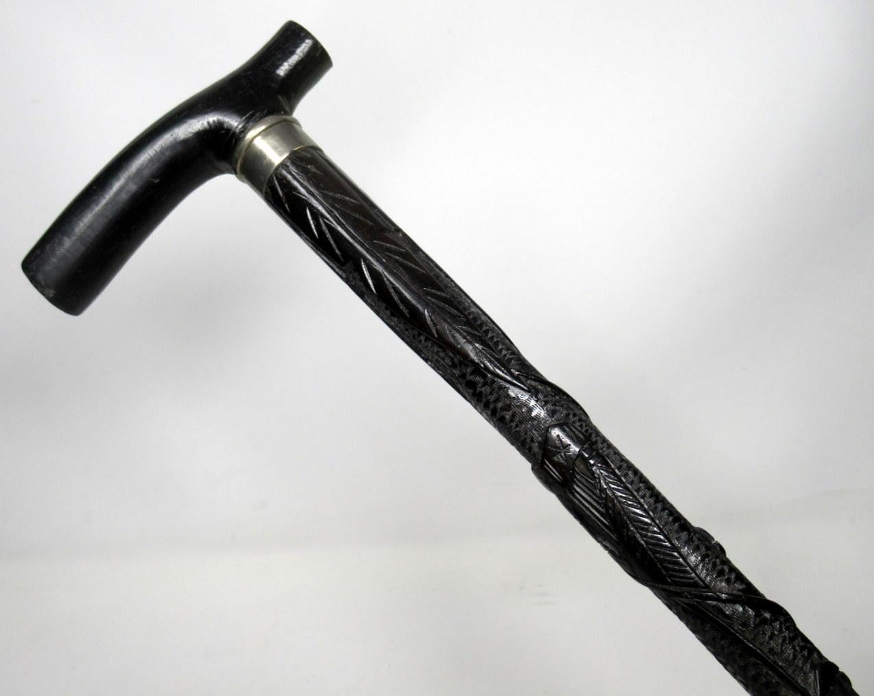 Hand carved Irish bog oak walking stick, of outstanding quality, made in Ireland during the last half of the 19th century.

The plain horizontal tau shaped grip above a finely carved shaft depicting an Irish Hearo, a round tower and an abundance of
