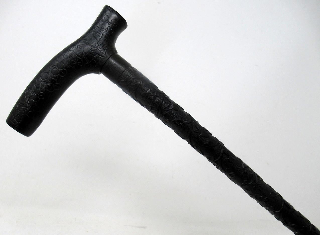 Extremely rare hand carved Irish Bog Oak Walking Stick, of outstanding quality, made in Ireland during the last half of the Nineteenth Century. 

The ornately carved horizontal tau shaped grip above a finely carved shaft depicting an abundance of